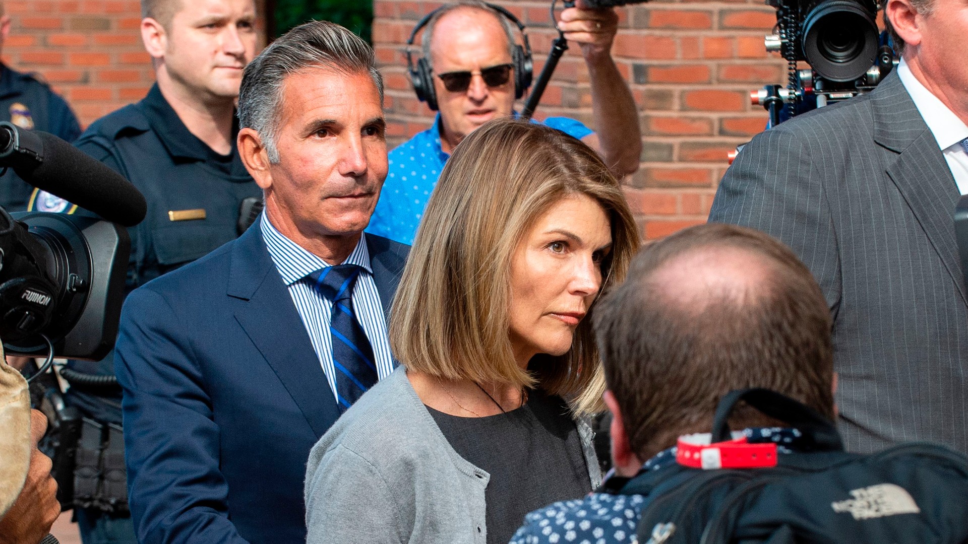 Actress Lori Loughlin and husband Mossimo Giannulli exit the Boston Federal Court house after a pre-trial hearing with Magistrate Judge Kelley at the John Joseph Moakley US Courthouse in Boston on August 27, 2019. (JOSEPH PREZIOSO/AFP via Getty Images)