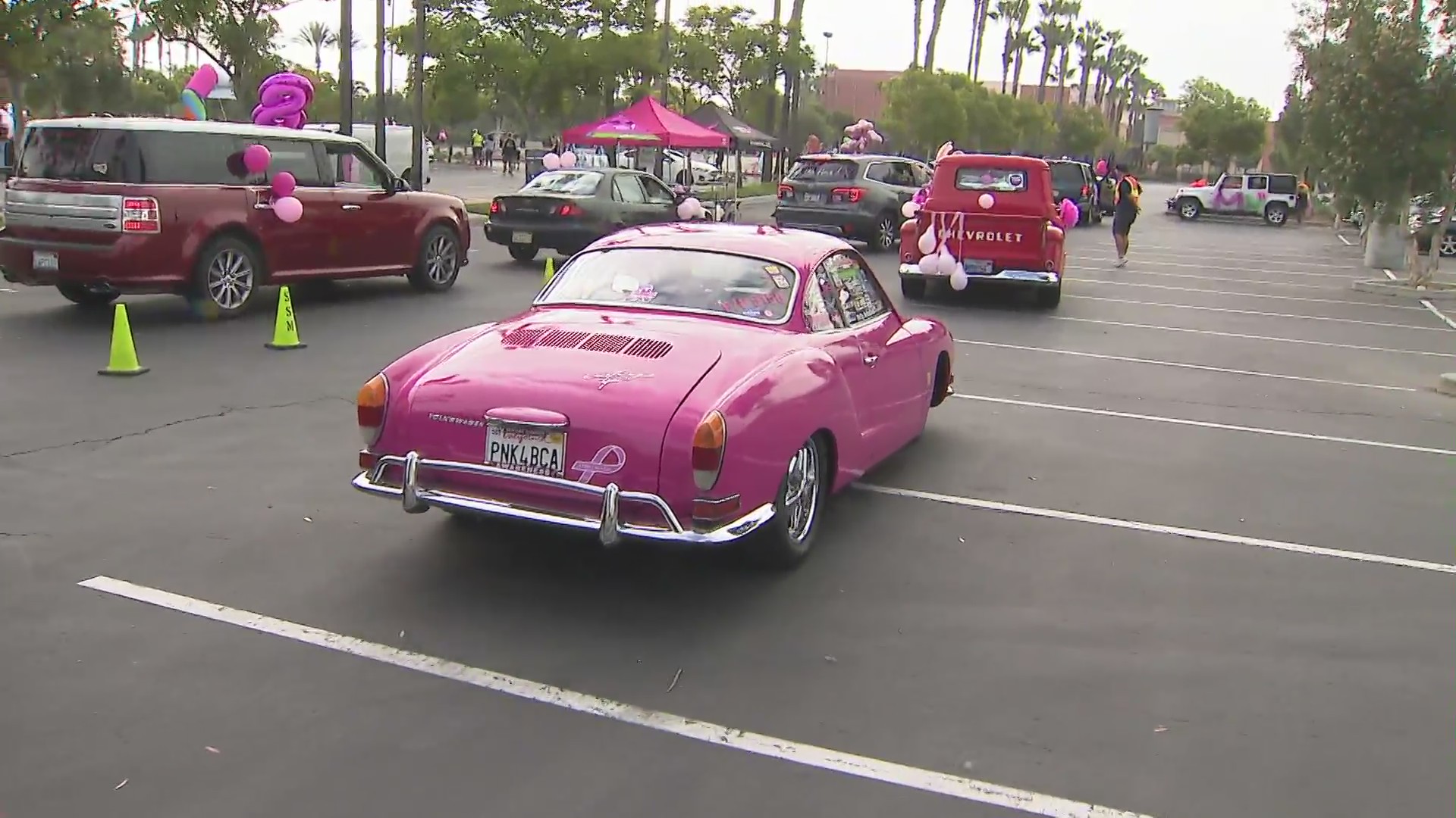 A pink car passes by in Tustin during a parade to raise breast cancer awareness. (KTLA)