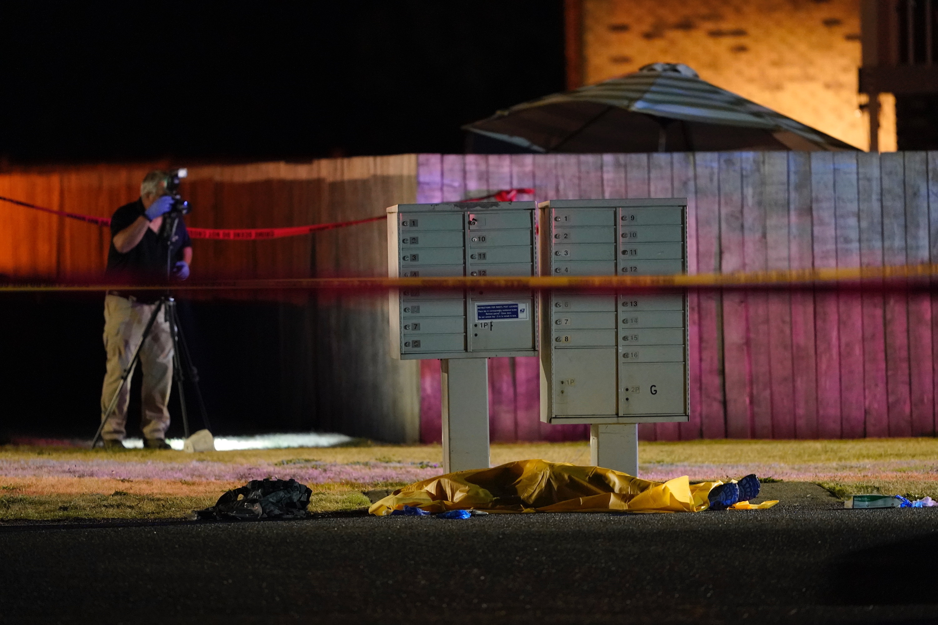 Officials work at a scene late on Sept. 3, 2020, where a man suspected of fatally shooting a supporter of a right-wing group in Portland, Oregon, the week before was killed as investigators moved in to arrest him in Lacey, Washington. (Ted Warren / Associated Press)