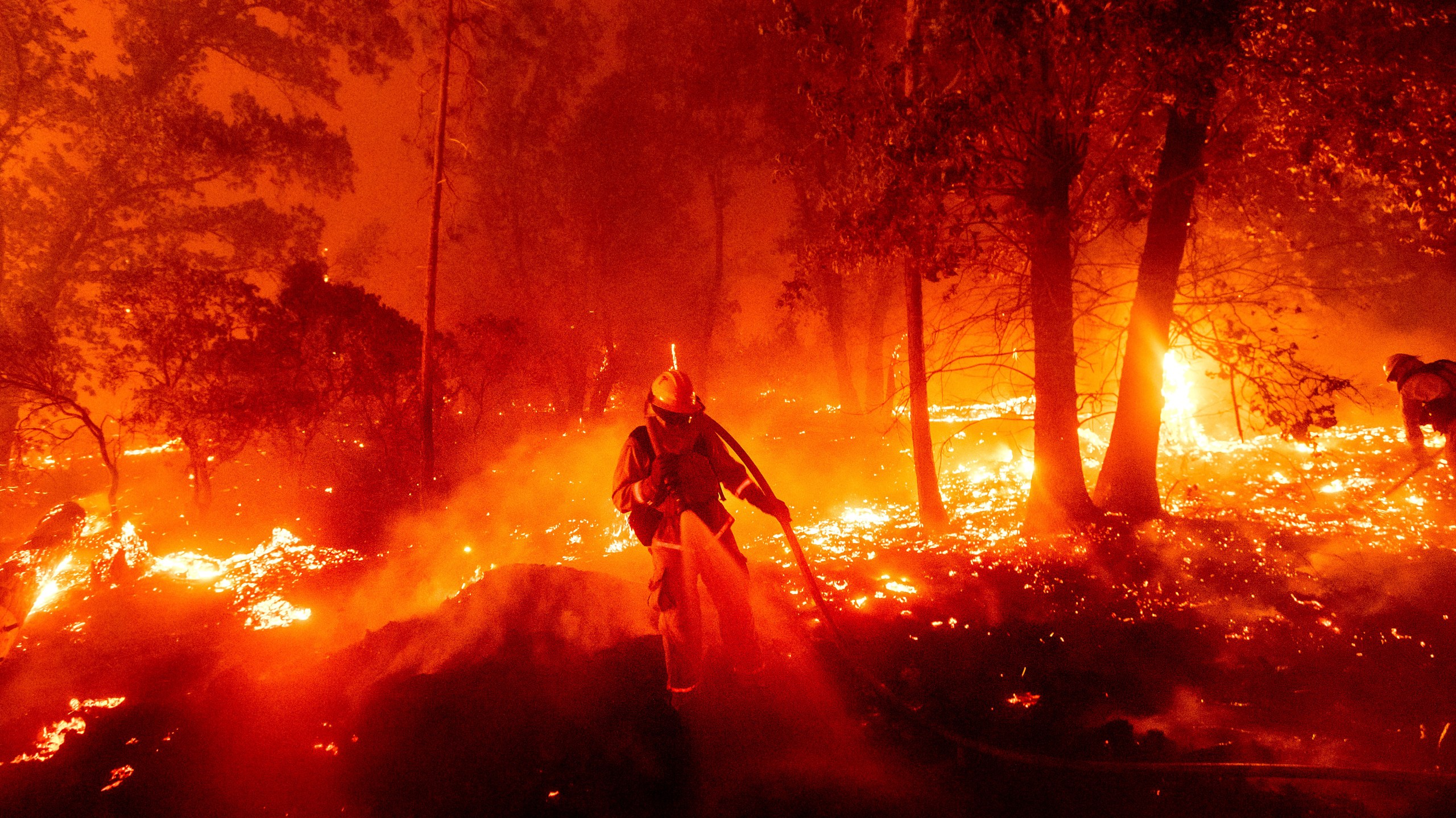 A firefighter battles the Creek Fire as it threatens homes in the Cascadel Woods neighborhood of Madera County on Sept. 7, 2020. (Noah Berger / Associated Press)