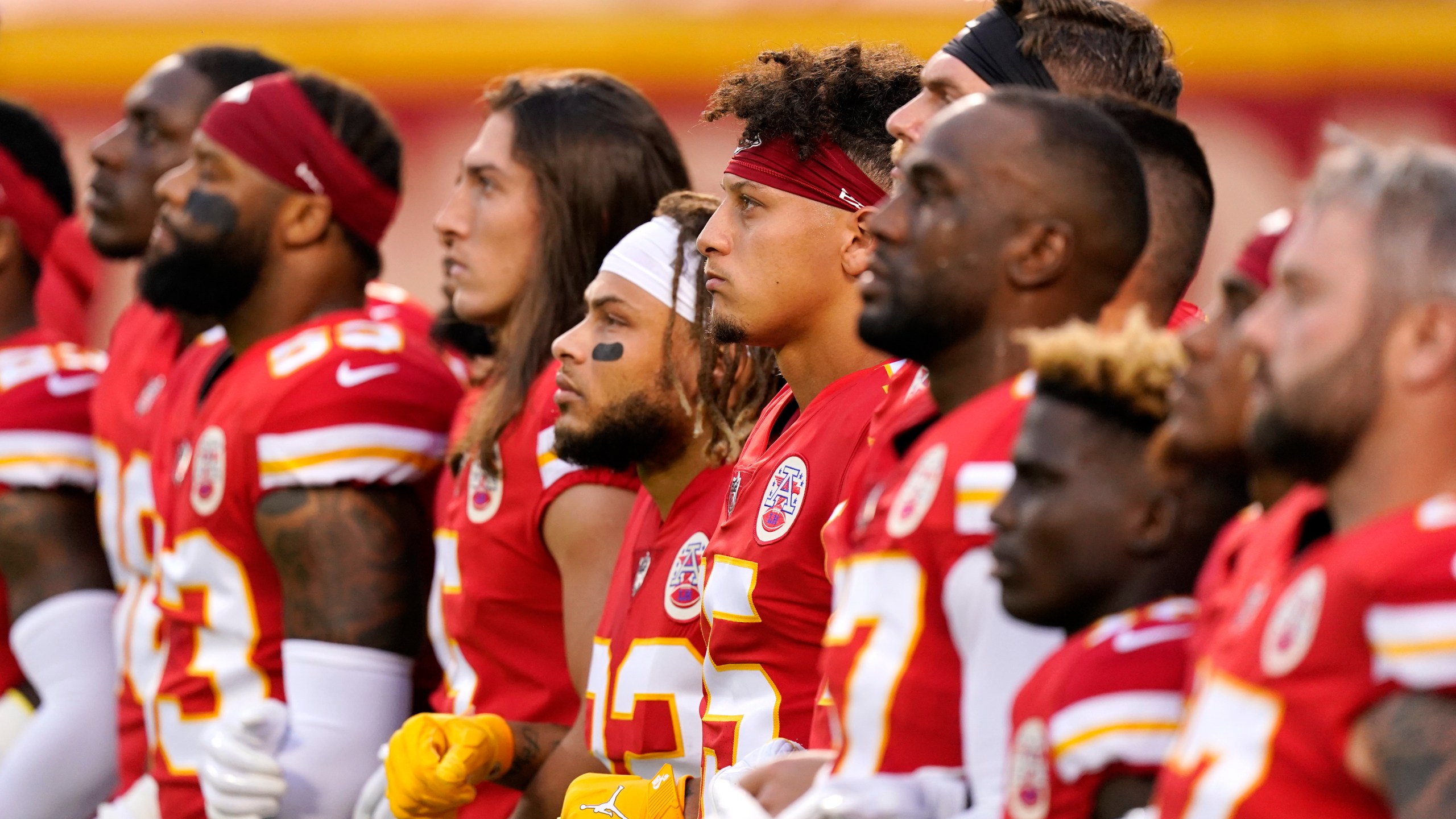 Kansas City Chiefs players, including quarterback Patrick Mahomes, No. 15, stand with teammates for a presentation on social justice before an NFL football game against the Houston Texans in Kansas City, Missouri, on Sept. 10, 2020. (Charlie Riedel / Associated Press)