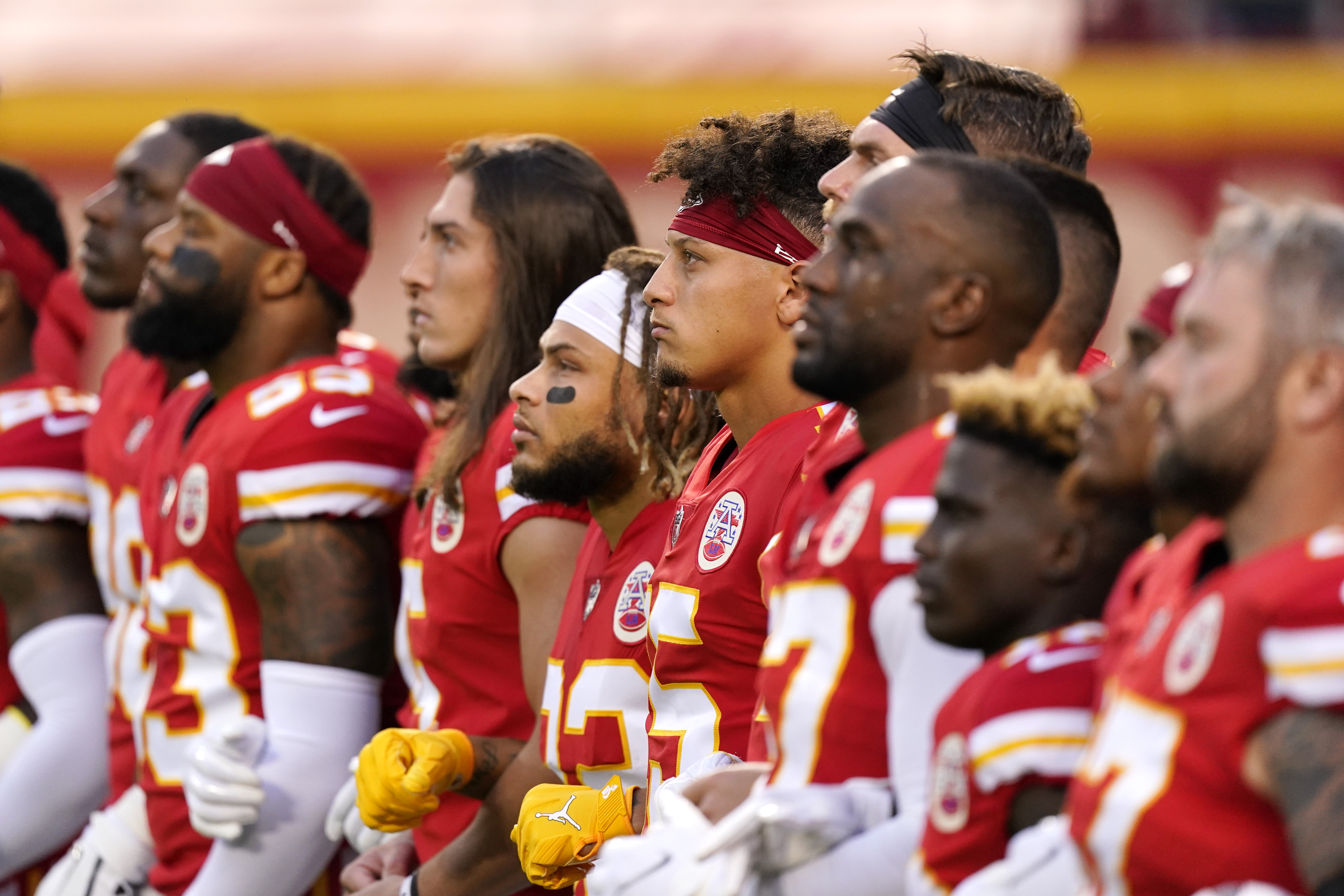 Kansas City Chiefs players, including quarterback Patrick Mahomes, No. 15, stand with teammates for a presentation on social justice before an NFL football game against the Houston Texans in Kansas City, Missouri, on Sept. 10, 2020. (Charlie Riedel / Associated Press)