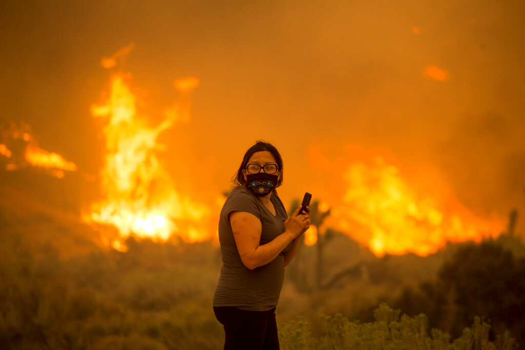 A woman watches as the Bobcat Fire burns in Juniper Hill, Calif., Friday, Sept. 18, 2020. (AP Photo/Ringo H.W. Chiu)