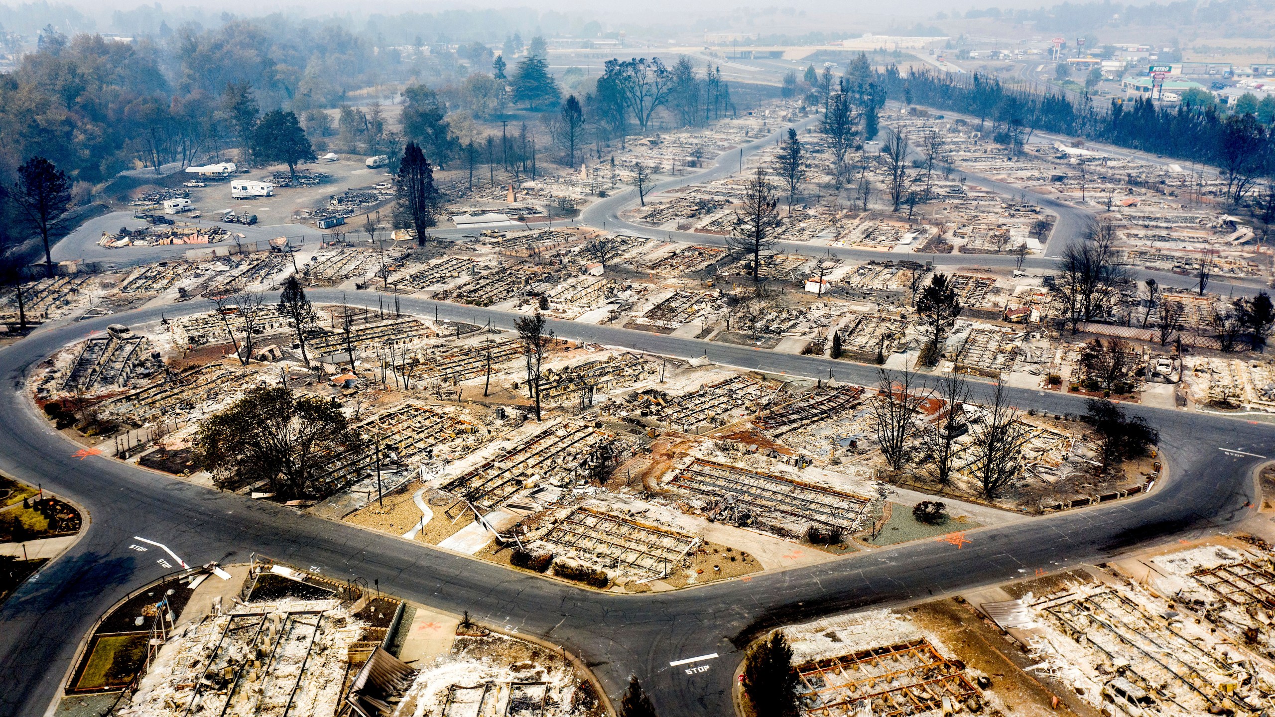 In this photo taken by a drone, homes leveled by the Almeda Fire line the Bear Lake Estates in Phoenix, Ore., Tuesday, Sept. 15, 2020. The Census Bureau is contending with several natural disasters as wildfires and hurricanes disrupt the final weeks of the nation’s once-a-decade headcount. (AP Photo/Noah Berger)