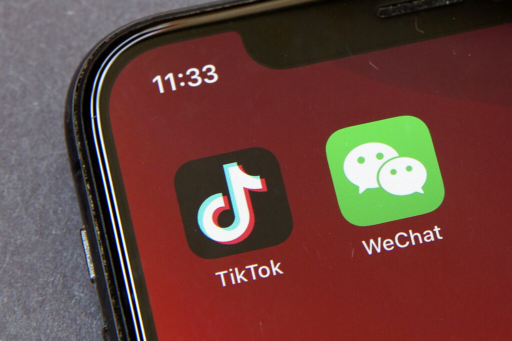 A file photo shows the app logos of TikTok and WeChat. (AP Photo/Mark Schiefelbein, File)