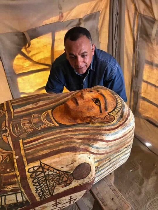 This September 2020 photo provided by the Ministry of Tourism and Antiquities shows Mostafa Waziri, secretary general of the Supreme Council of Antiquities, posing with one of more than two dozen ancient coffins unearthed near the famed Step Pyramid of Djoser in Saqqara, south of Cairo, Egypt. (Ministry of Tourism and Antiquities via AP)