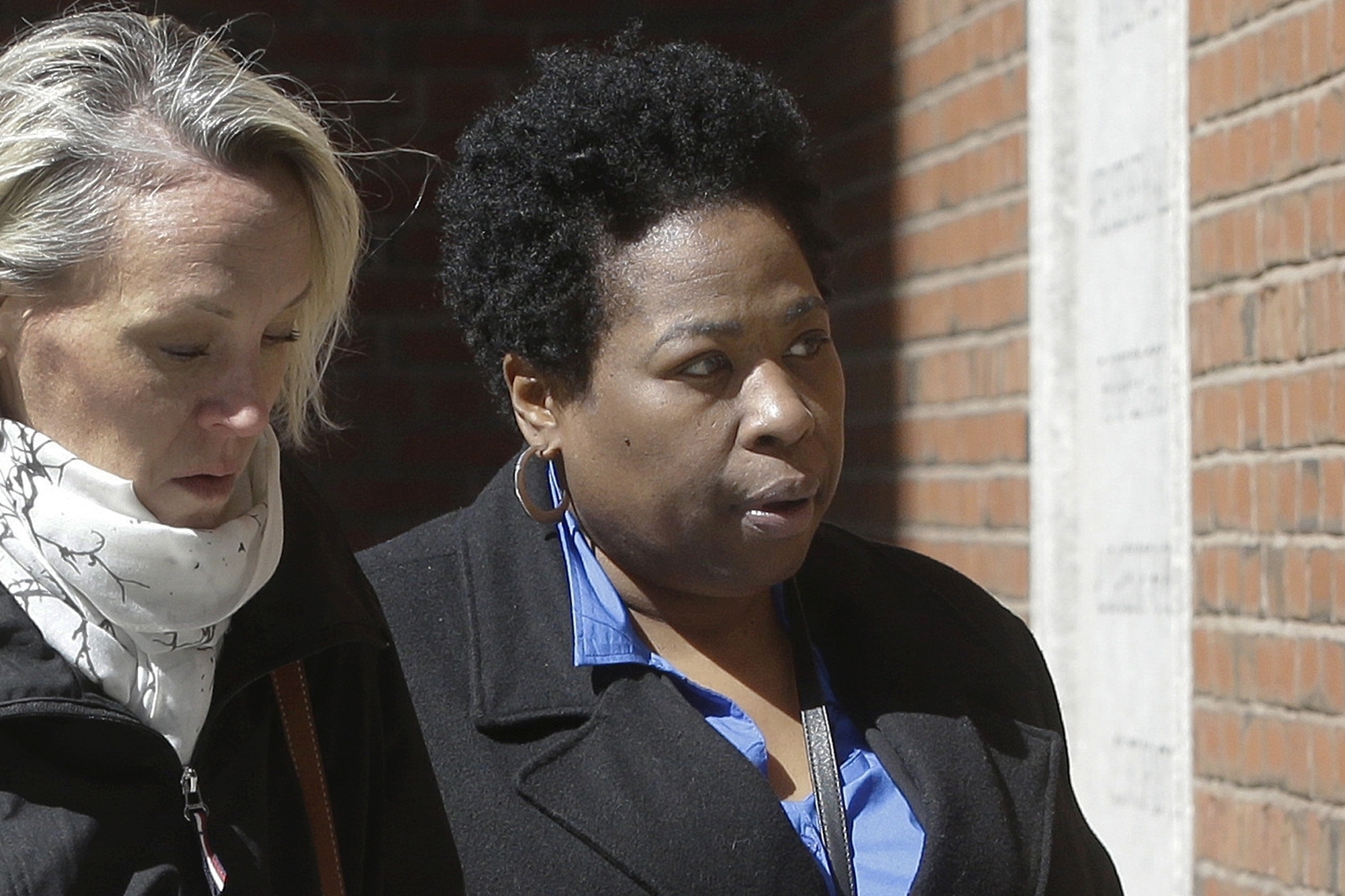 In this March 25, 2019, file photo, Niki Williams, right, a college entrance exam administrator, arrives at federal court in Boston to face charges in a nationwide college admissions bribery scandal. Williams pleaded guilty to charges on Friday, Sept. 25, 2020. (AP Photo/Steven Senne, File)