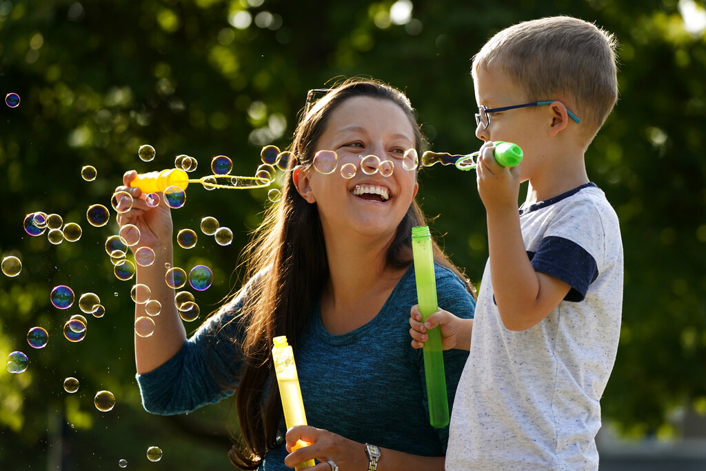 Claire Reagan plays with her son Evan, 5, Monday, Sept. 21, 2020, outside her home in Olathe, Kansas. (AP Photo/Charlie Riedel)