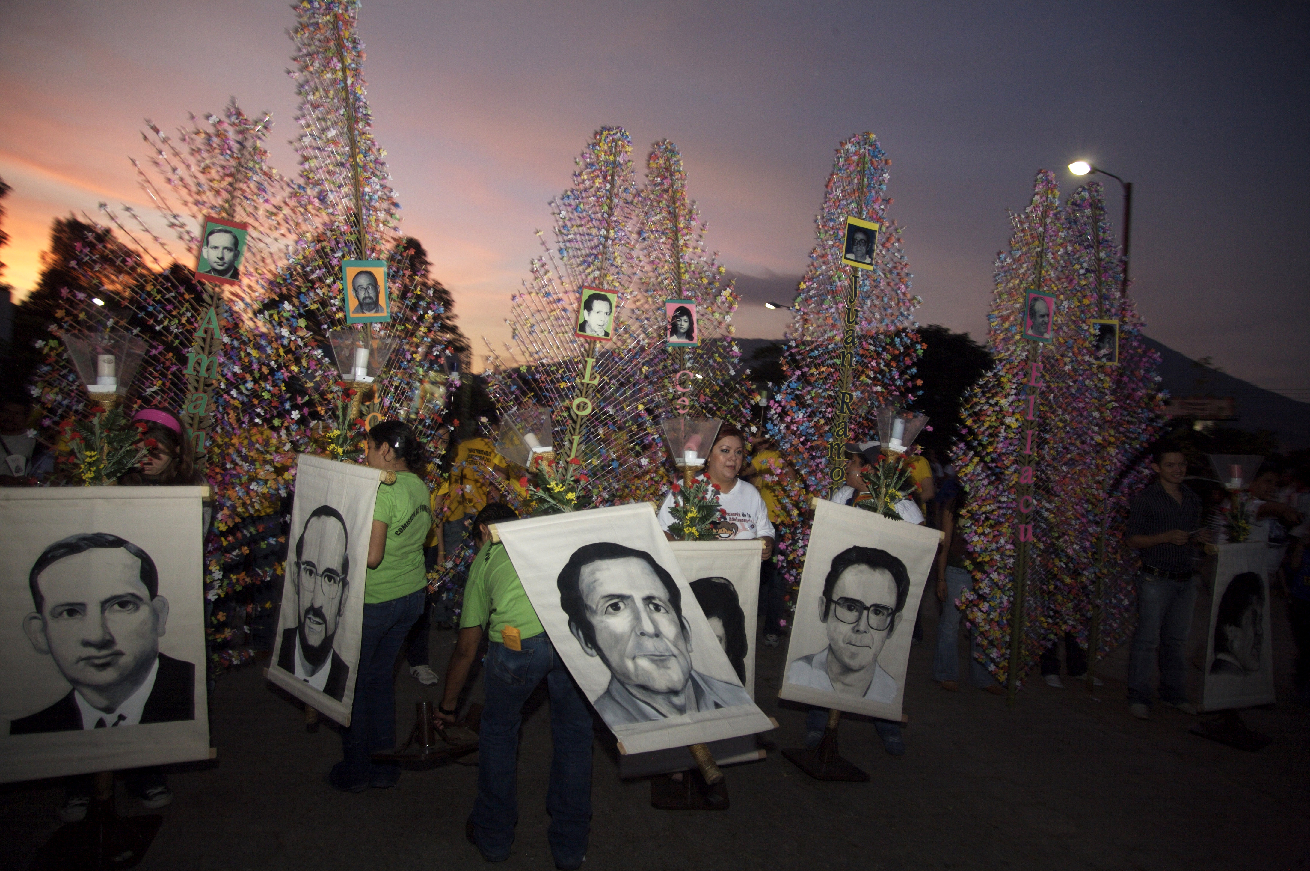 In this Nov. 15, 2008 file photo, people hold banners depicting six Jesuit priests massacred in 1989, during a memorial to mark the 19th anniversary of their death, in San Salvador. For years, attempts within El Salvador to investigate and prosecute the masterminds of the massacre during that country’s civil war have been delayed and deflected by legal maneuvers. (Edgar Romero/AP Photo File)