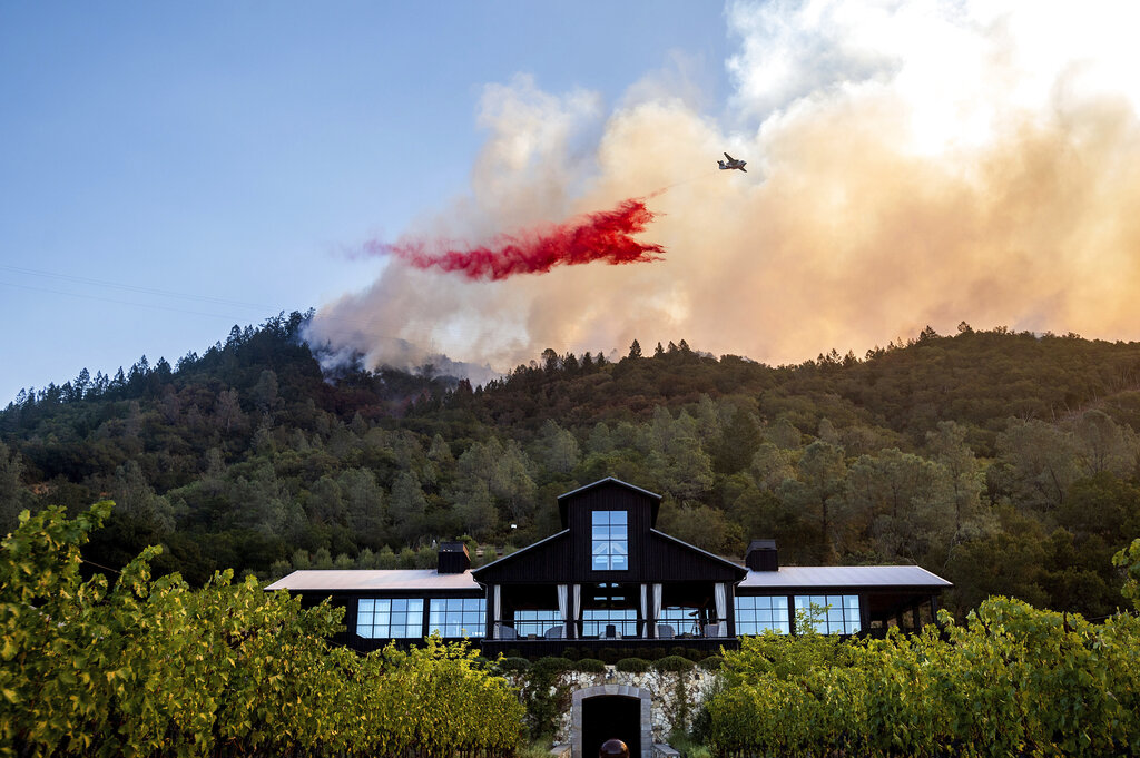 An air tanker drops retardant on the Glass Fire burning above Davis Estates winery in Calistoga, Calif., on Sept. 27, 2020. (AP Photo/Noah Berger)