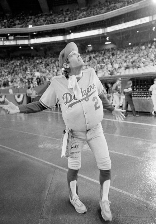 In this Oct. 18, 1981, file photo, Los Angeles Dodgers outfielder Jay Johnstone, wearing a padded version of manager Tommy Lasorda's uniform, checks the progress of a rain delay before a National League Playoff baseball game with the Expos in Montreal. Johnstone, who won World Series championships as a versatile outfielder with the New York Yankees and Los Angeles Dodgers while being baseball’s merry prankster, died Saturday, Sept. 26, of complications from COVID-19 at a nursing home in Granada Hills, Calif., his daughter Mary Jayne Sarah Johnstone said Monday, Sept. 28, 2020. He was 74. He also from dementia in recent years, his daughter said. (AP Photo/Barrett, File)