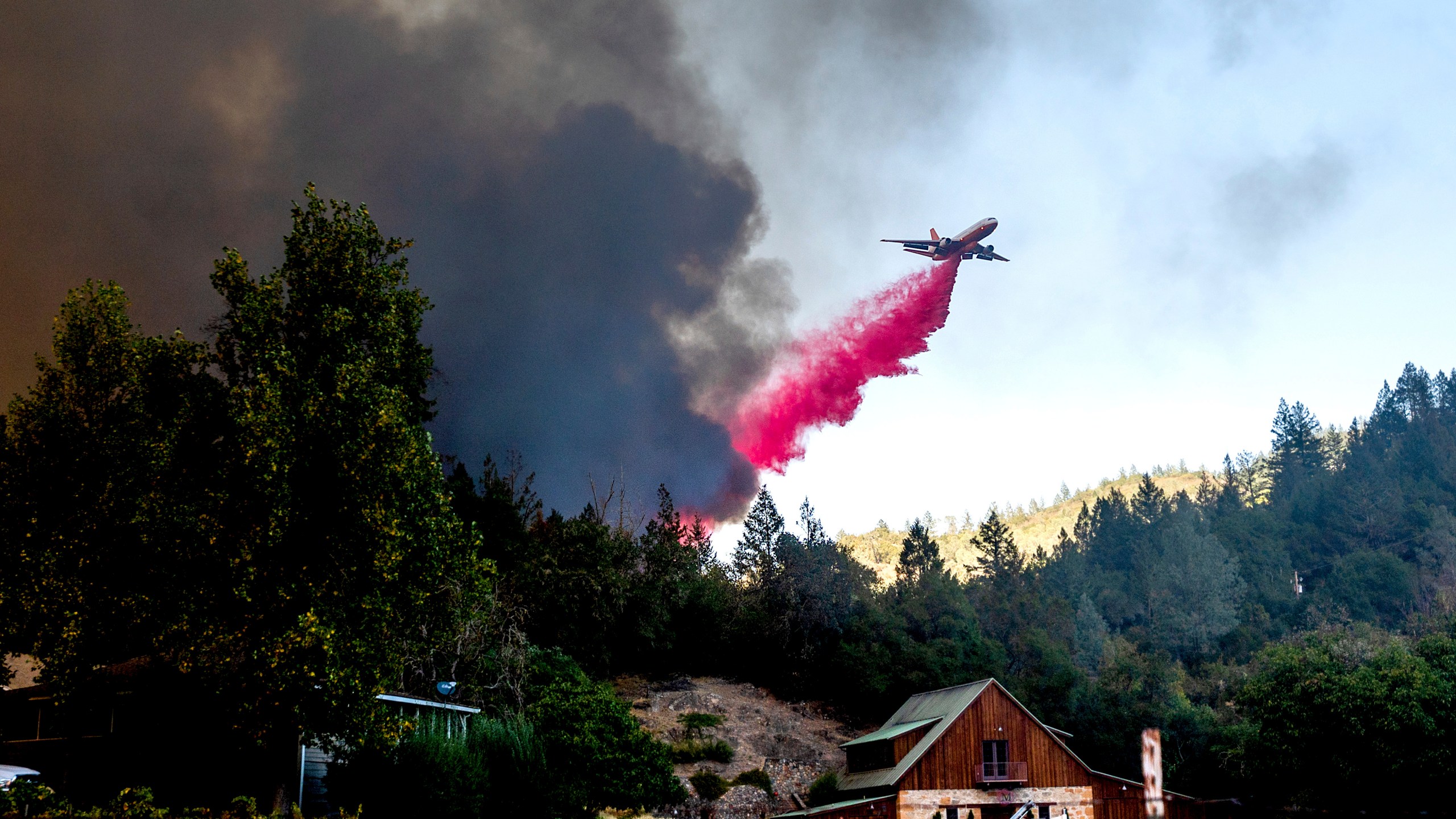 An air tanker drops retardant while battling the Glass Fire in St. Helena, Calif., on Sunday, Sept. 27, 2020. (AP Photo/Noah Berger)