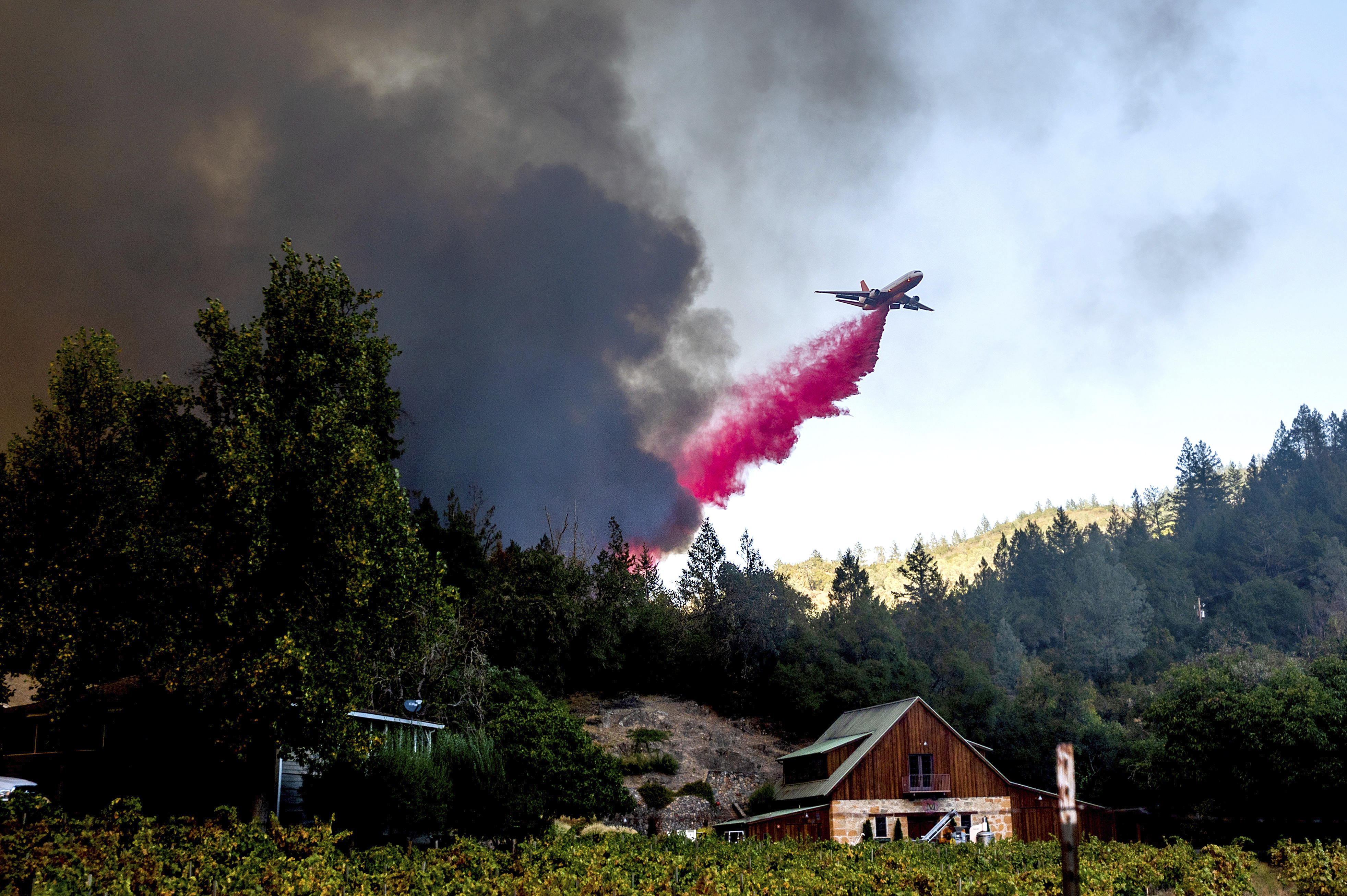 An air tanker drops retardant while battling the Glass Fire in St. Helena, Calif., on Sunday, Sept. 27, 2020. (AP Photo/Noah Berger)