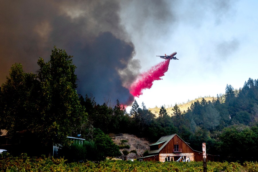 An air tanker drops retardant while battling the Glass Fire in St. Helena, Calif., on Sunday, Sept. 27, 2020. (AP Photo/Noah Berger)