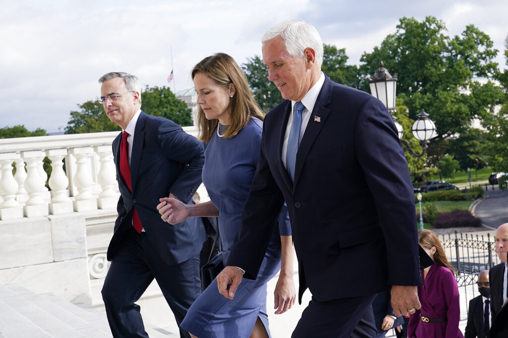 Judge Amy Coney Barrett, President Donald Trump's nominee for the U.S. Supreme Court, is escorted to the Senate by Vice President Mike Pence, right, where she will begin a series of meetings to prepare for her confirmation hearing, at the Capitol in Washington, Tuesday, Sept. 29, 2020. (AP Photo/Susan Walsh, POOL)