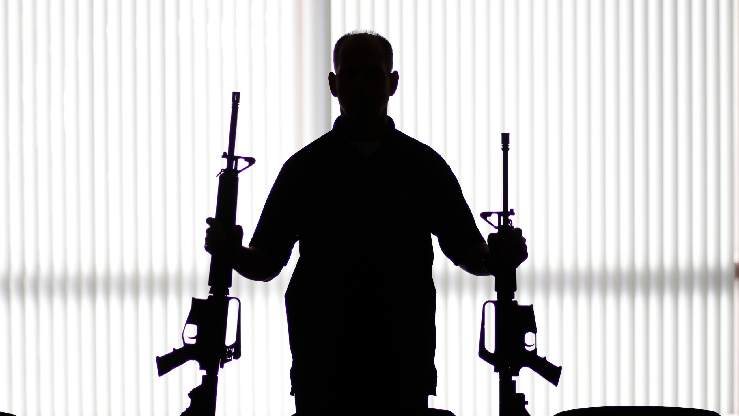 In this Aug. 29, 2017, file photo, an ATF agent poses with homemade rifles, or "ghost guns," at an ATF field office in Glendale. (Jae C. Hong/Associated Press)