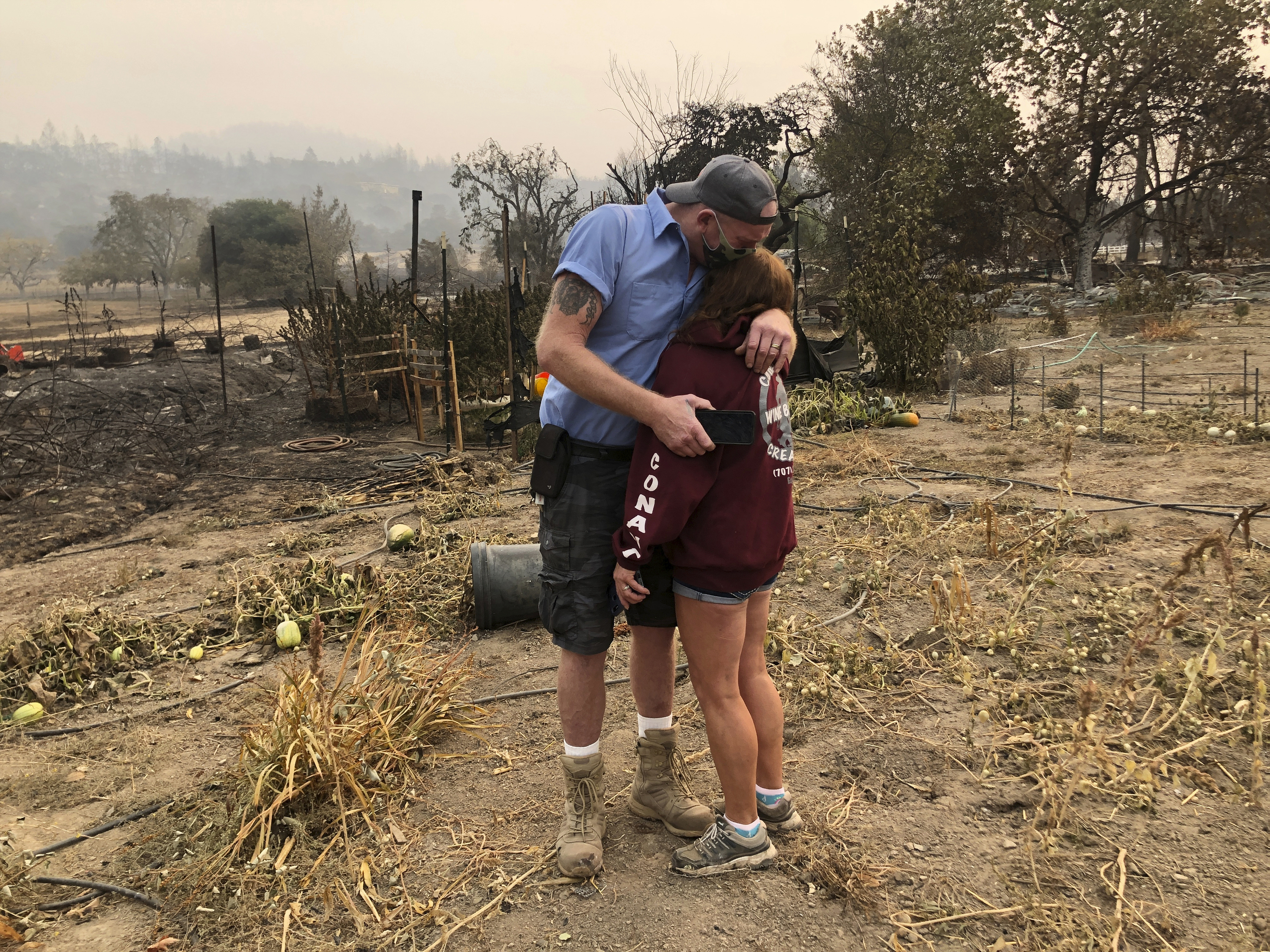 Kevin Conant and his wife, Nikki, hug after looking at the debris of their burnt Santa Rosa home and business "Conants Wine Barrel Creations" on Sept. 30, 2020, after the Glass/Shady fire completely engulfed it. (Haven Daley / Associated Press)