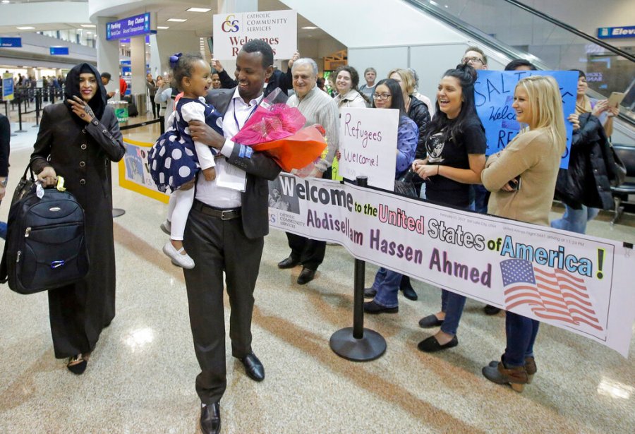 Abdisellam Hassen Ahmed, a Somali refugee who had been stuck in limbo after President Donald Trump temporarily banned refugee entries, walks with his wife Nimo Hashi, and his 2-year-old daughter, Taslim, who he met for the first time after arriving at Salt Lake City International Airport on Feb. 10, 2017. (AP Photo/Rick Bowmer, File)