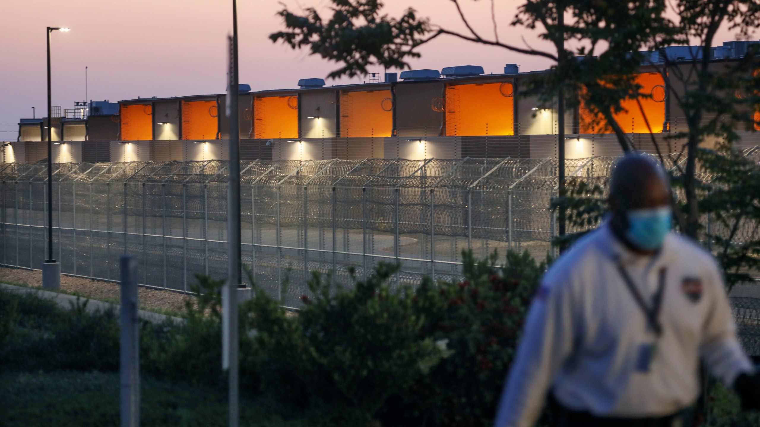 A security guard patrols outside of the Otay Mesa Correctional Facility during a "Vigil for Carlos" rally on May 9, 2020 in Otay Mesa, California. - The vigil was held to commemorate Carlos Ernesto Escobar Mejia, the first illegal immigrant who died of COVID-19 related symptoms while being held at the detention Center. (Photo by SANDY HUFFAKER / AFP) (Photo by SANDY HUFFAKER/AFP via Getty Images)