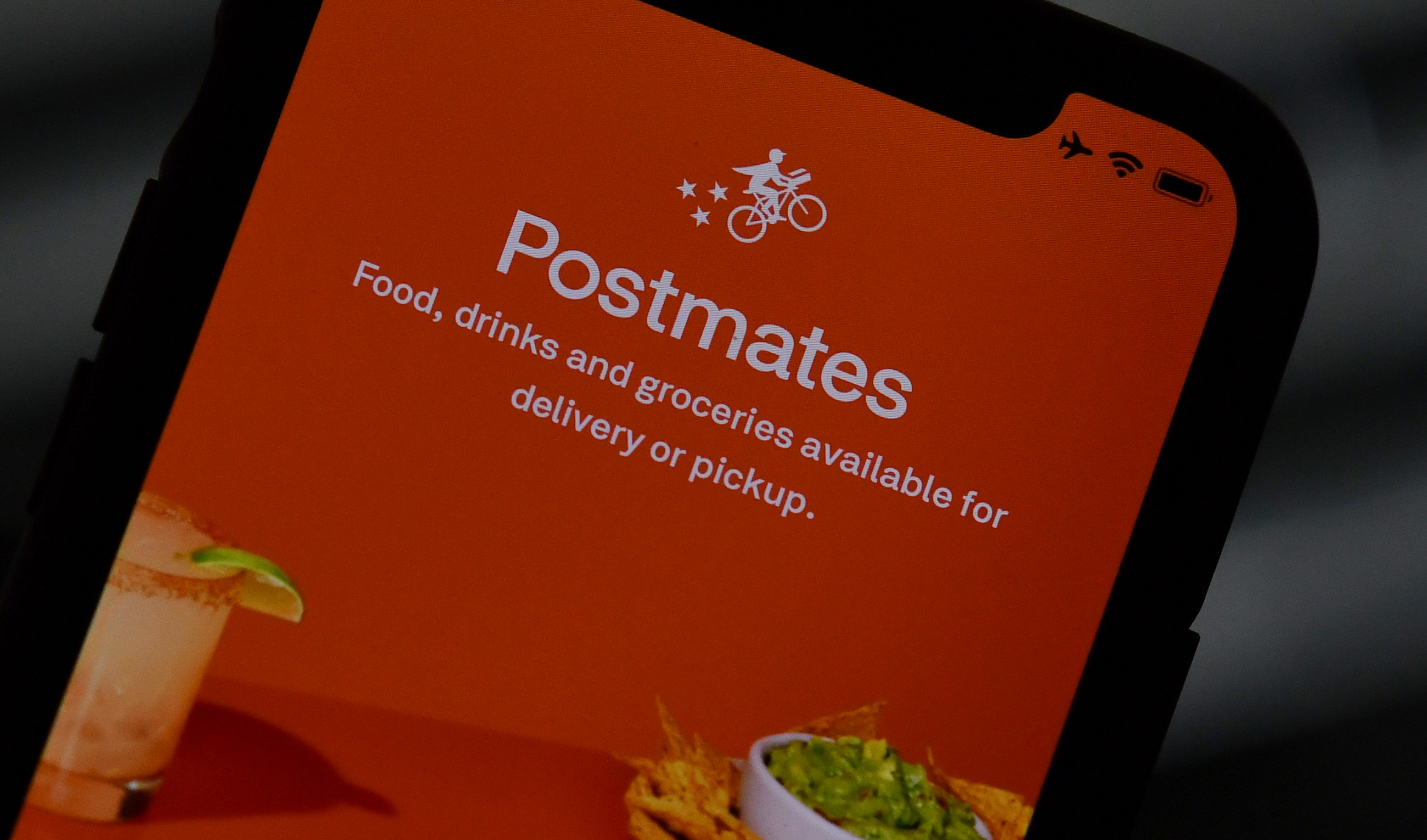 This illustration photo taken on June 30, 2020, shows the logo of delivery app Postmates on a smartphone screen in Los Angeles. (Chris Delmas / AFP / Getty Images)