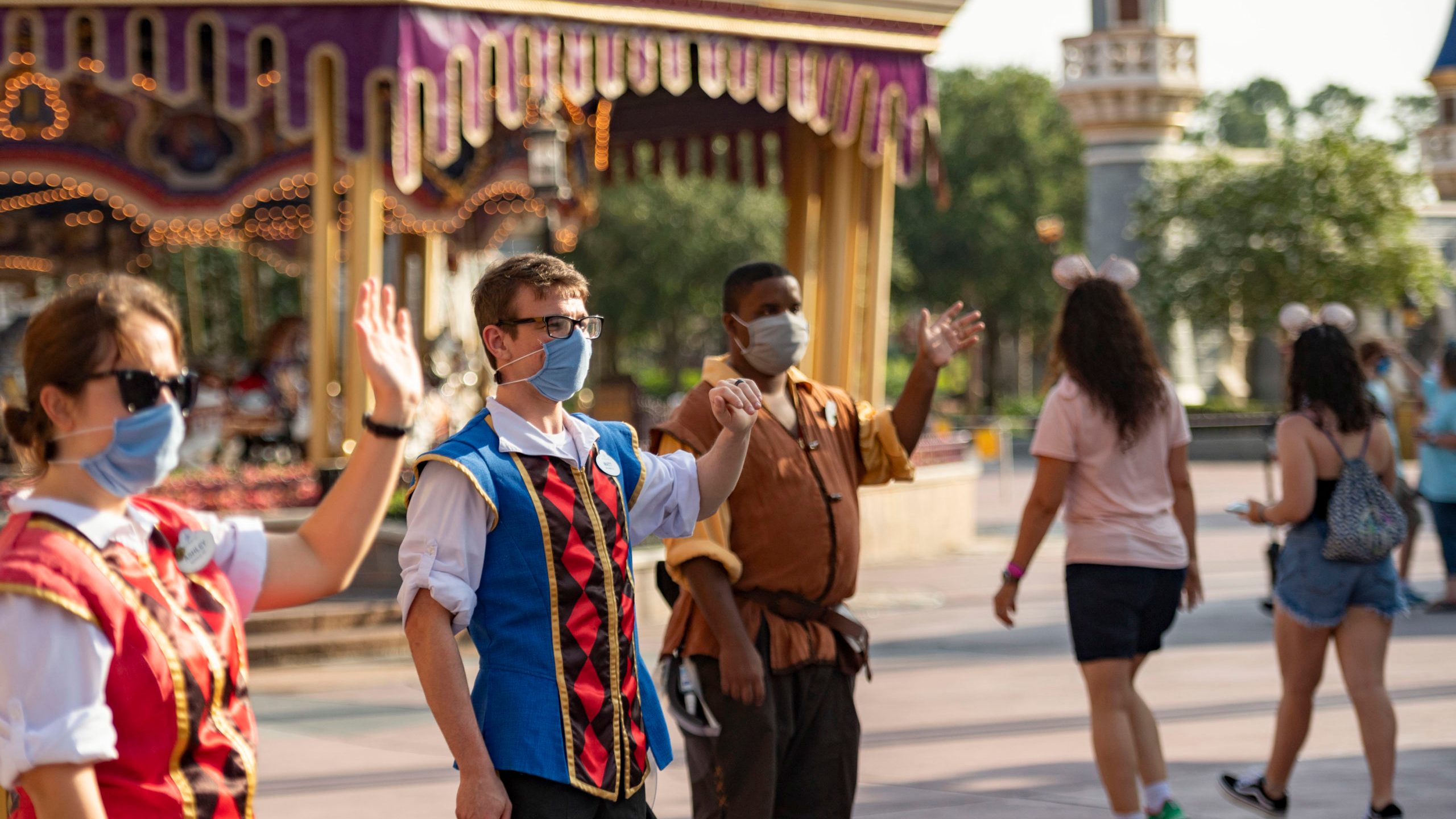 In this handout photo provided by Walt Disney World Resort, Disney cast members welcome guests to Magic Kingdom Park at Walt Disney World Resort on July 11, 2020 in Lake Buena Vista, Florida. (Matt Stroshane/Walt Disney World Resort via Getty Images)