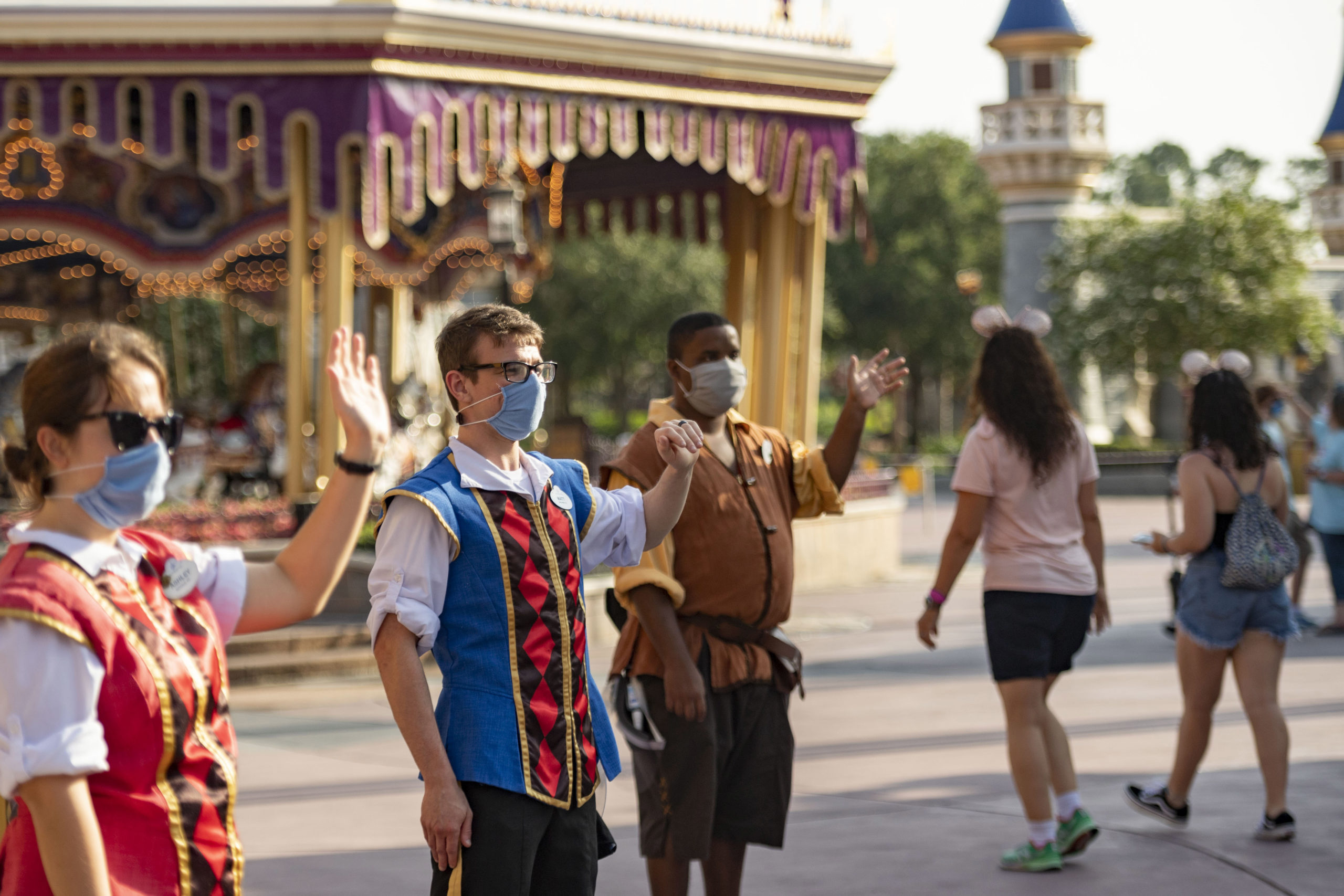 In this handout photo provided by Walt Disney World Resort, Disney cast members welcome guests to Magic Kingdom Park at Walt Disney World Resort on July 11, 2020 in Lake Buena Vista, Florida. (Matt Stroshane/Walt Disney World Resort via Getty Images)