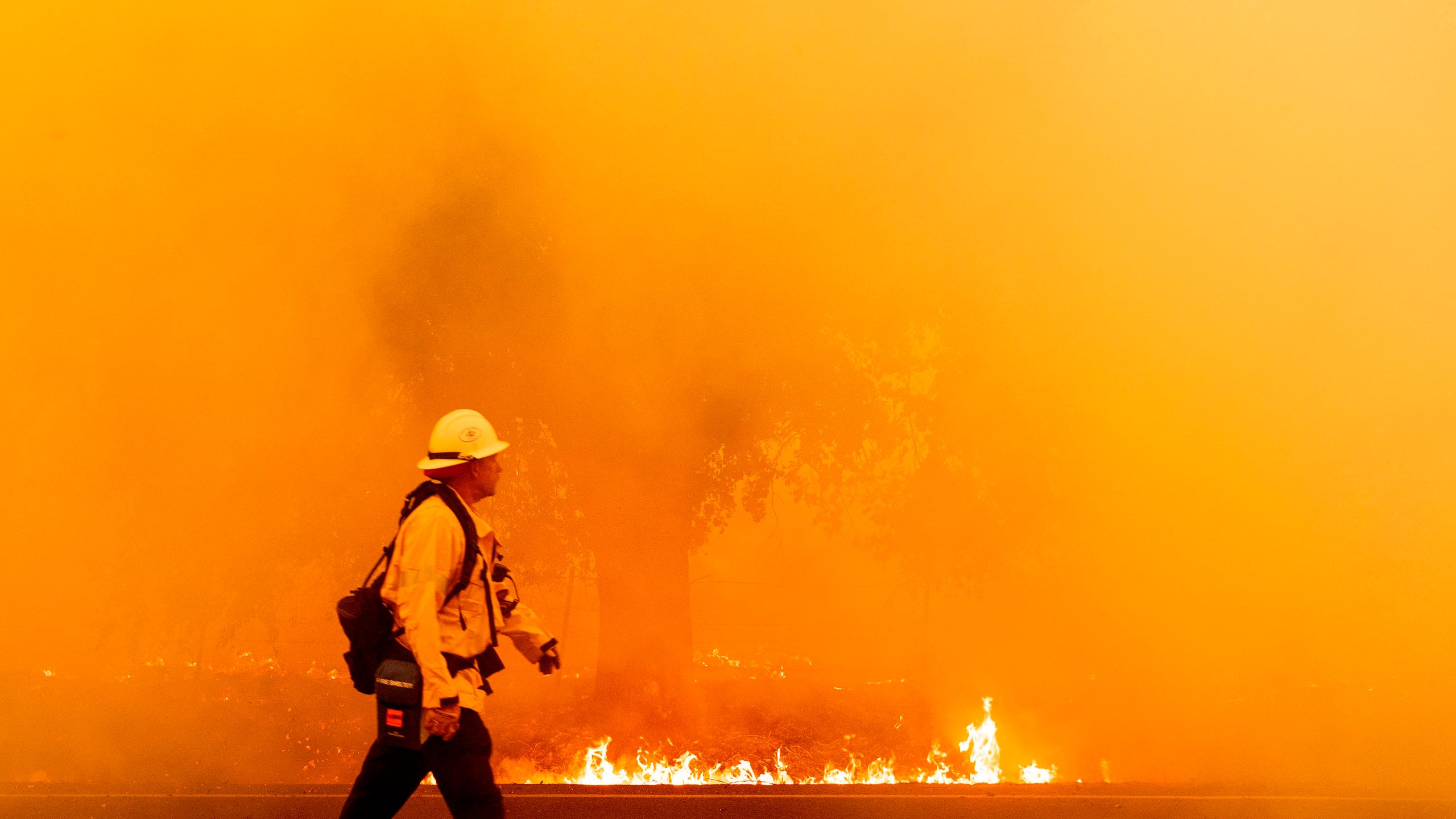 A Pacific Gas and Electric firefighter walks down a road as flames approach in Fairfield, Calif. during the LNU Lightning Complex fire on Aug. 19, 2020. (JOSH EDELSON/AFP via Getty Images)