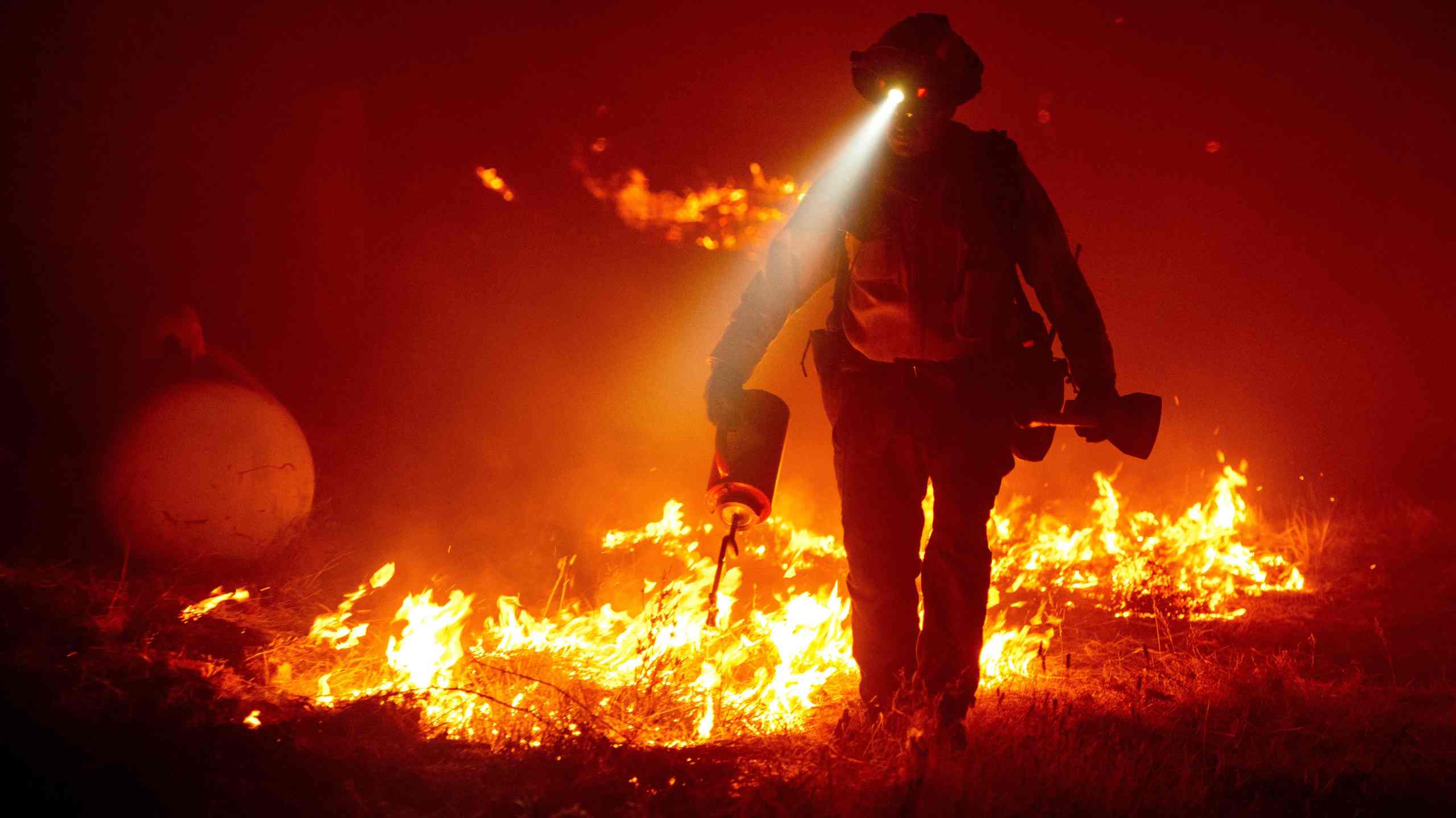 Firefighters cut defensive lines and light backfires to protect structures behind a CalFire fire station during the Bear fire, part of the North Lightning Complex fires in the Berry Creek area of unincorporated Butte County, California on September 9, 2020. - (JOSH EDELSON/AFP via Getty Images)