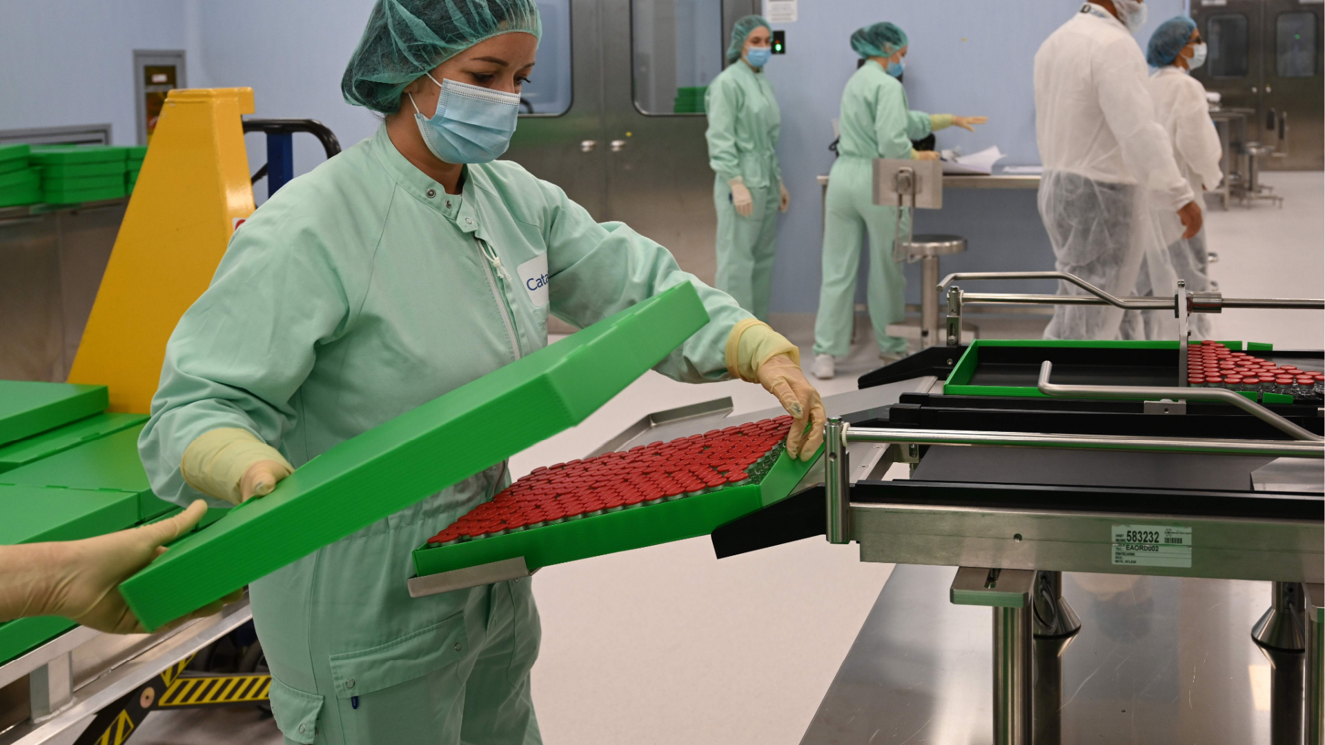 A laboratory technician handles capped vials as part of filling and packaging tests for the large-scale production and supply of the University of Oxfords COVID-19 vaccine candidate, conducted on a high-performance aseptic vial filling line on Sept. 11, 2020. (VINCENZO PINTO/AFP via Getty Images)