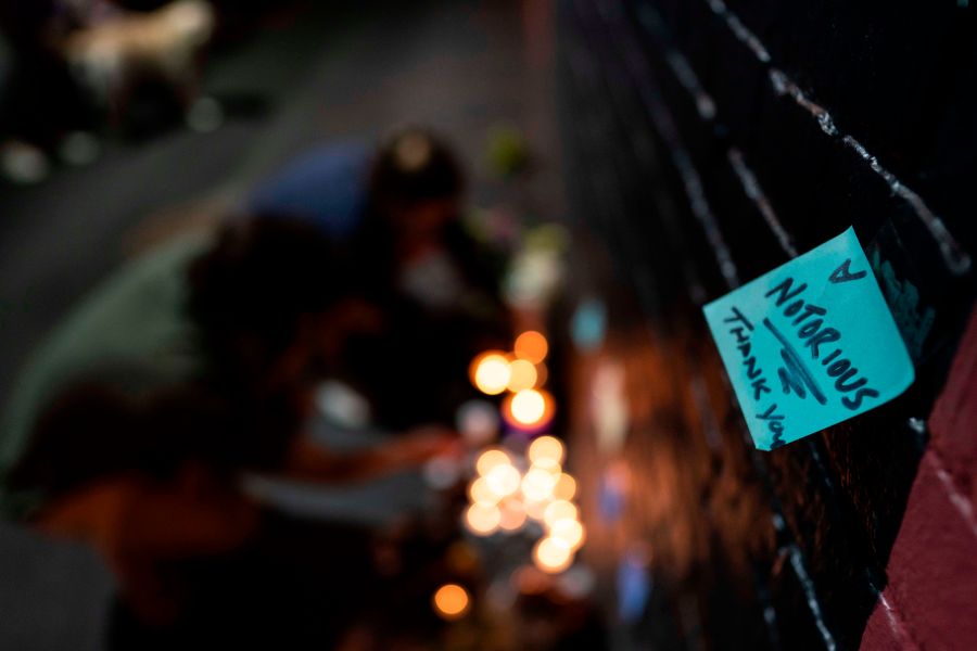 A note is placed near mourners lighting candles below a mural of late U.S. Supreme Court Justice Ruth Bader Ginsburg by artist Rose Jaffe, in Washington, D.C., late on Sept. 18, 2020. (ALEX EDELMAN/AFP via Getty Images)