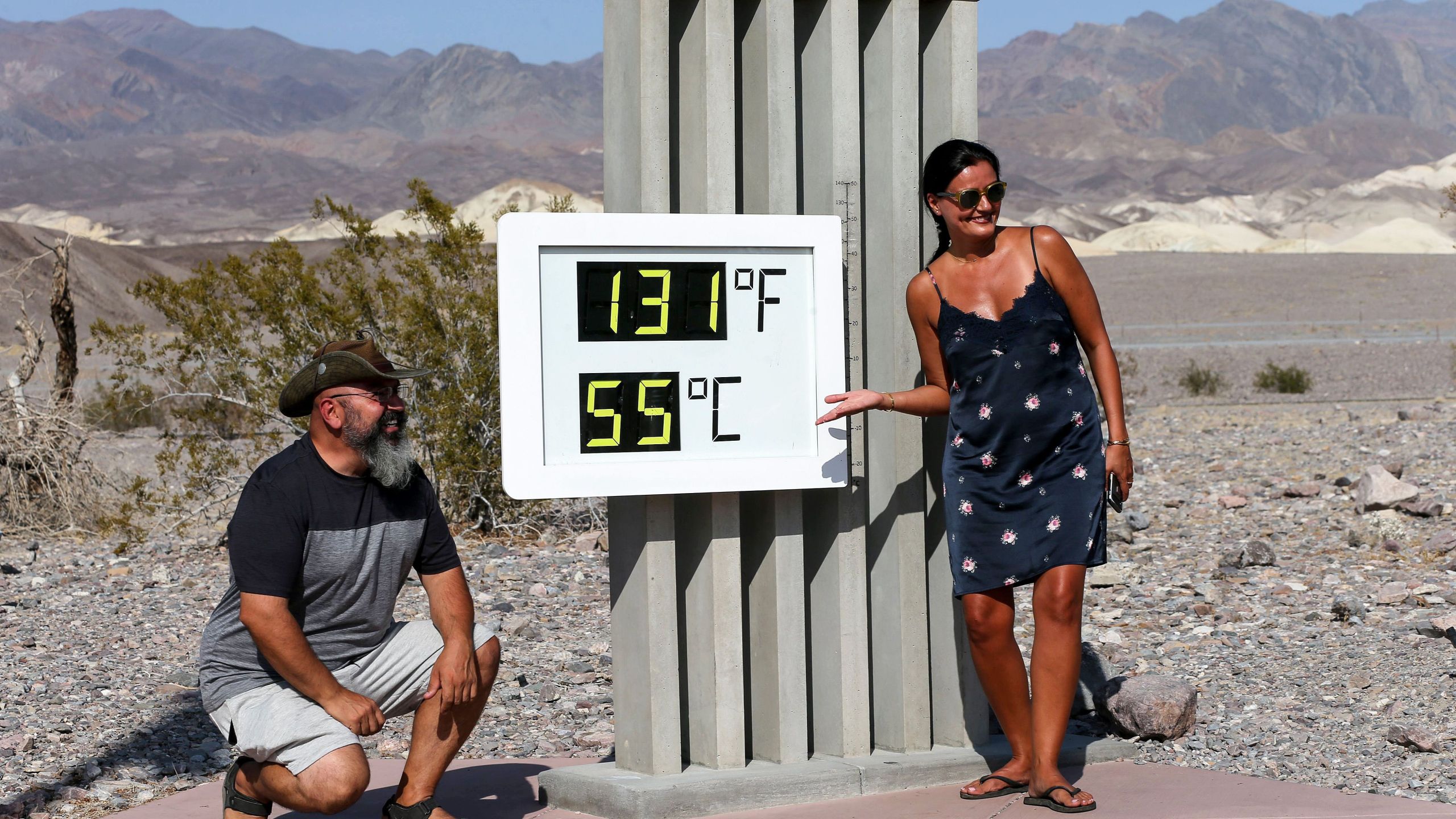 Visitors gather for a photo in front of an unofficial thermometer at Furnace Creek Visitor Center on August 17, 2020 in Death Valley National Park. (Mario Tama/Getty Images)