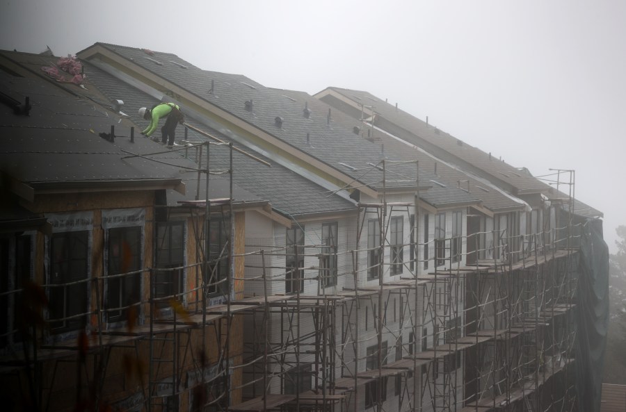 A worker stands on the roof of a new home under construction on September 24, 2020 in South San Francisco. Justin Sullivan/Getty Images)