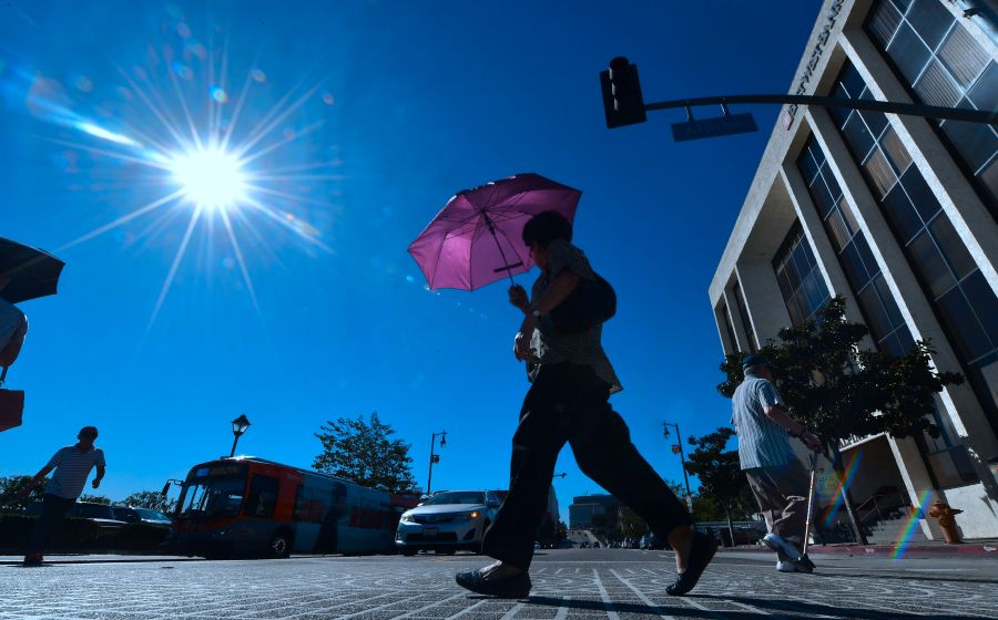 A pedestrian uses an umbrella on a hot sunny morning in Los Angeles in this file photo. (FREDERIC J. BROWN/AFP via Getty Images)