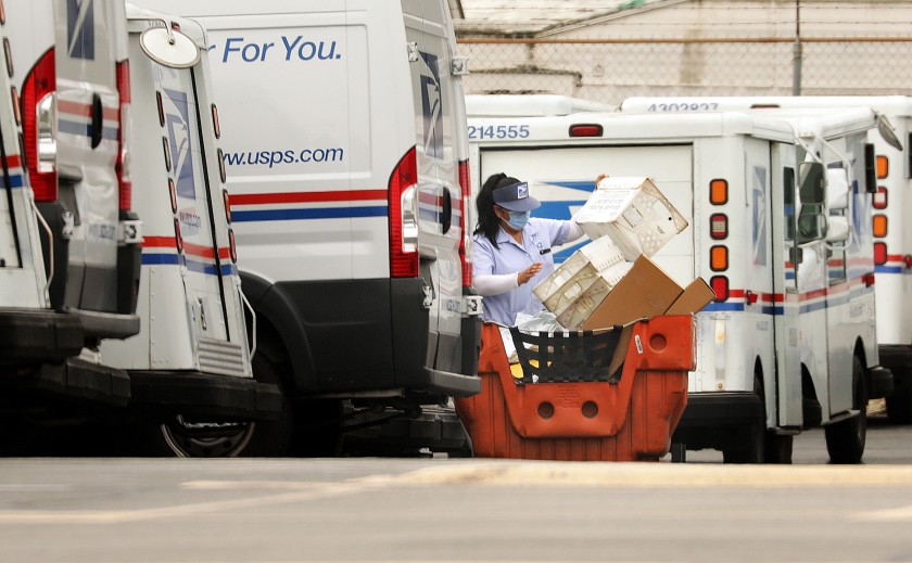 A mail carrier loads a truck for delivery at a post office in Torrance.(Christina House/Los Angeles Times)