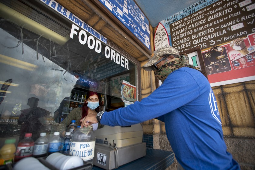 Aileen Delaportilla, left, a business major at Golden West College, receives a tip from customer Ron Mancillas of Fresno on Monday.(Allen J. Schaben / Los Angeles Times)