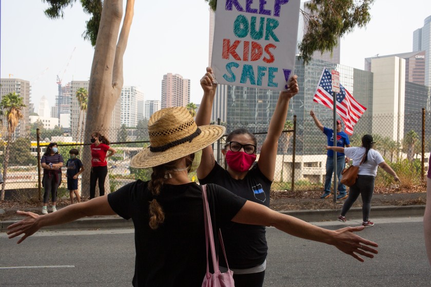 A Black Lives Matter protester blocks a counter-protester from entering a student-led rally that called for defunding school police. L.A. school board members on Tuesday reviewed potential cuts to the district police department.(Gabriella Angotti-Jones / Los Angeles Times)