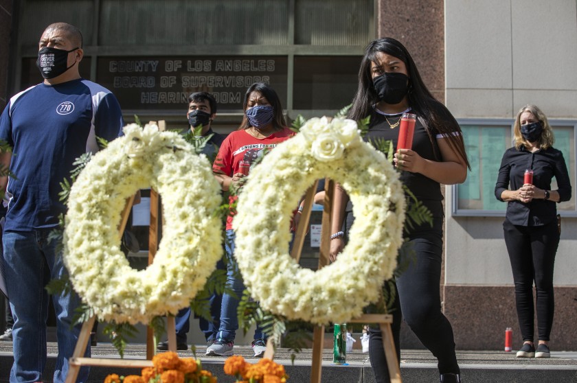 Overhill Farms workers take part in an Aug. 31 memorial ceremony in front of the Kenneth Hahn Hall of Administration in downtown Los Angeles to honor those who have died of COVID-19.(Mel Melcon / Los Angeles Times)