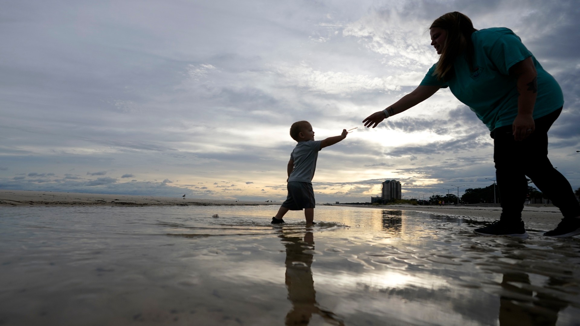 Nikita Pero of Gulfport, Miss., walks with her son Vinny Pero, 2, on the beach along the Gulf of Mexico in Biloxi, Miss., Monday, Sept. 14, 2020. (AP Photo/Gerald Herbert)