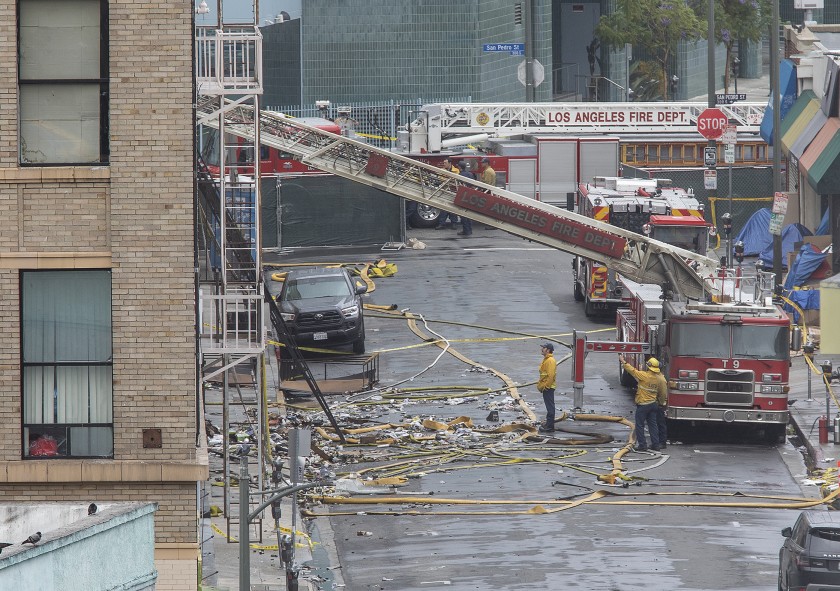 Members of the Los Angeles Fire Department investigate the scene of a fiery explosion on May 16, 2020, that injured 11 firefighters on Boyd Street in downtown Los Angeles. (Mel Melcon / Los Angeles Times)