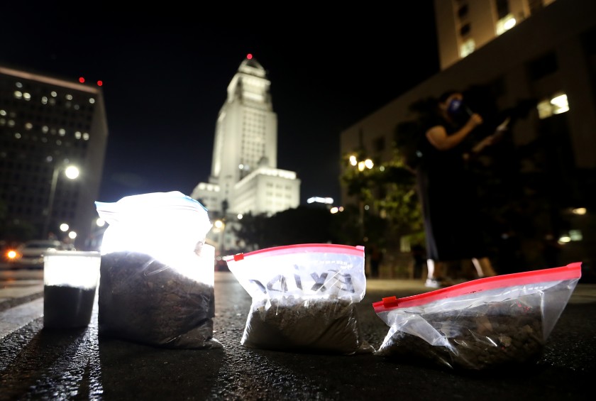 Protesters left bags of lead-contaminated dirt in downtown L.A. on Oct. 19, 2020, during a demonstration against a court ruling allowing owners of the Exide battery recycling plant in Vernon to abandon the facility, leaving the cleanup to California taxpayers. (Luis Sinco / Los Angeles Times)