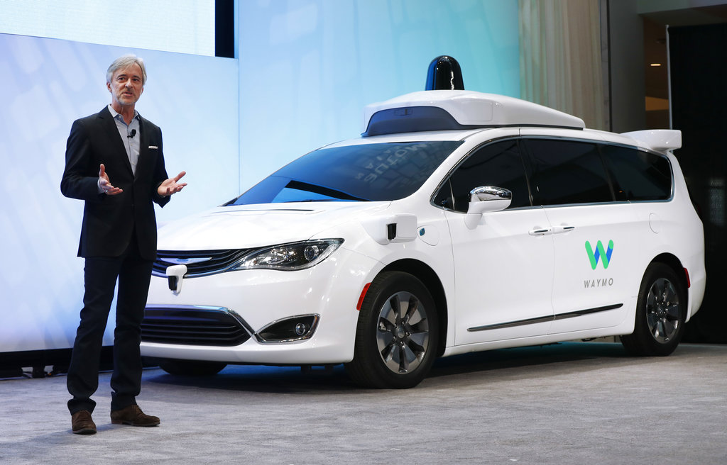 In this Jan. 8, 2017, file photo, John Krafcik, CEO of Waymo, the autonomous vehicle company created by Google's parent company, Alphabet, introduces a Chrysler Pacifica hybrid outfitted with Waymo's own suite of sensors and radar, at the North American International Auto Show in Detroit. (AP Photo/Paul Sancya, File)