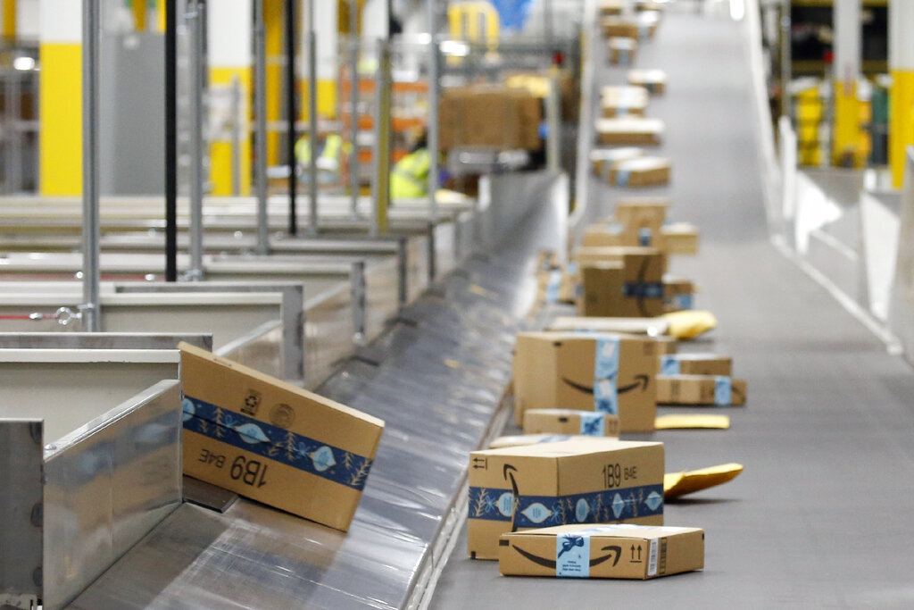 In this Dec. 17, 2019, file photo, Amazon packages move along a conveyor at an Amazon warehouse facility in Goodyear, Ariz. (AP Photo/Ross D. Franklin, File)