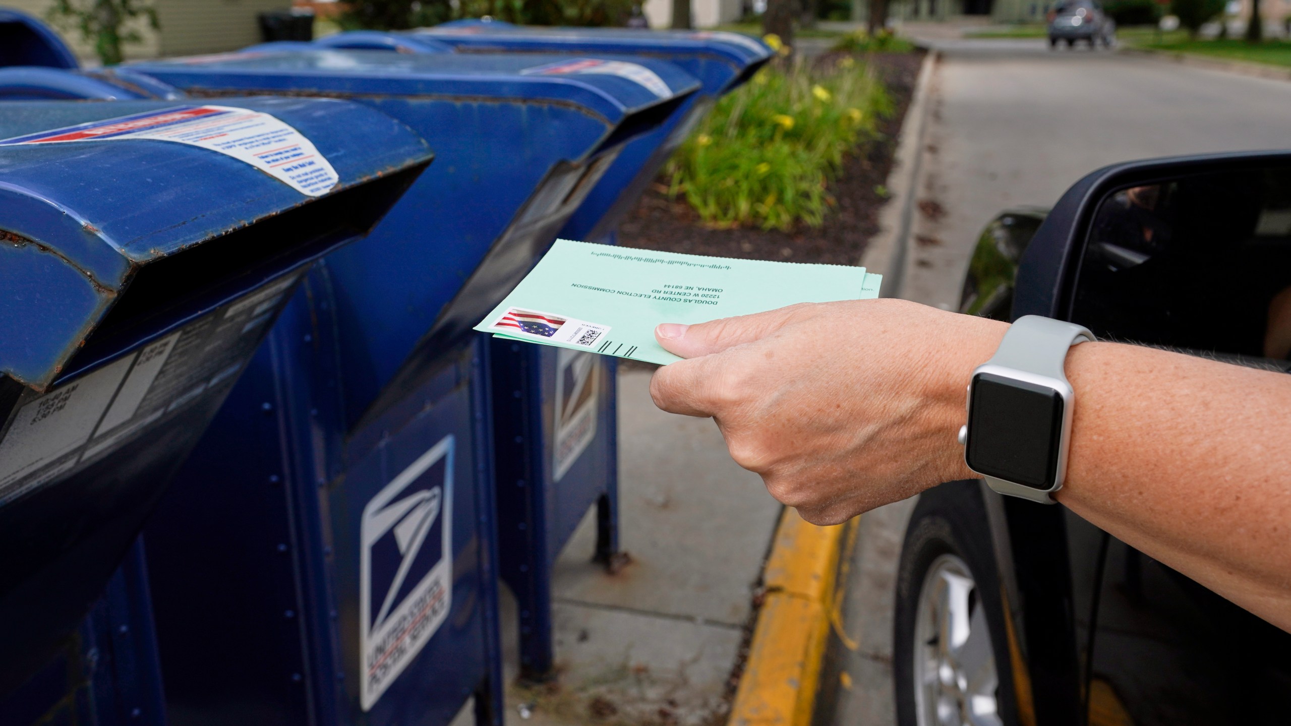 In this Tuesday, Aug. 18, 2020, file photo, a person drops applications for mail-in-ballots into a mail box in Omaha, Neb. (Nati Harnik/AP Photo)