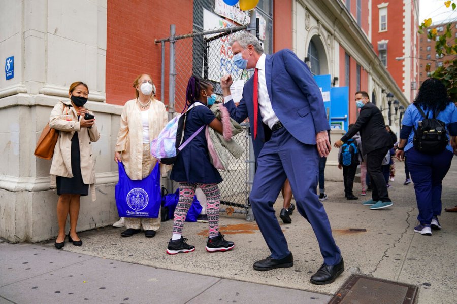 New York Mayor Bill de Blasio, center right, greets students as they arrive for in-person classes outside Public School 188 The Island School on Sept. 29, 2020, in the Manhattan borough of New York. (AP Photo/John Minchillo)