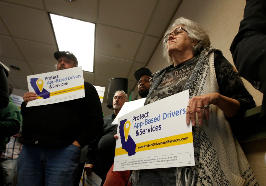 In this Oct. 29, 2019, photo, Carla Shrive, right, who drives for various gig companies, joined other drivers to support a proposed ballot initiative challenging a recently signed law that makes it harder for companies to label workers as independent contractors, in Sacramento. A battle between the powerhouses of the so-called gig economy and big labor could become the most expensive ballot measure on Nov. 3, 2020, in California history. Voters are being asked to decide via Proposition 22 whether to create an exemption to a new state law aimed at providing wage and benefit protections to Uber, Lyft and other app-based drivers. (AP Photo/Rich Pedroncelli, File)