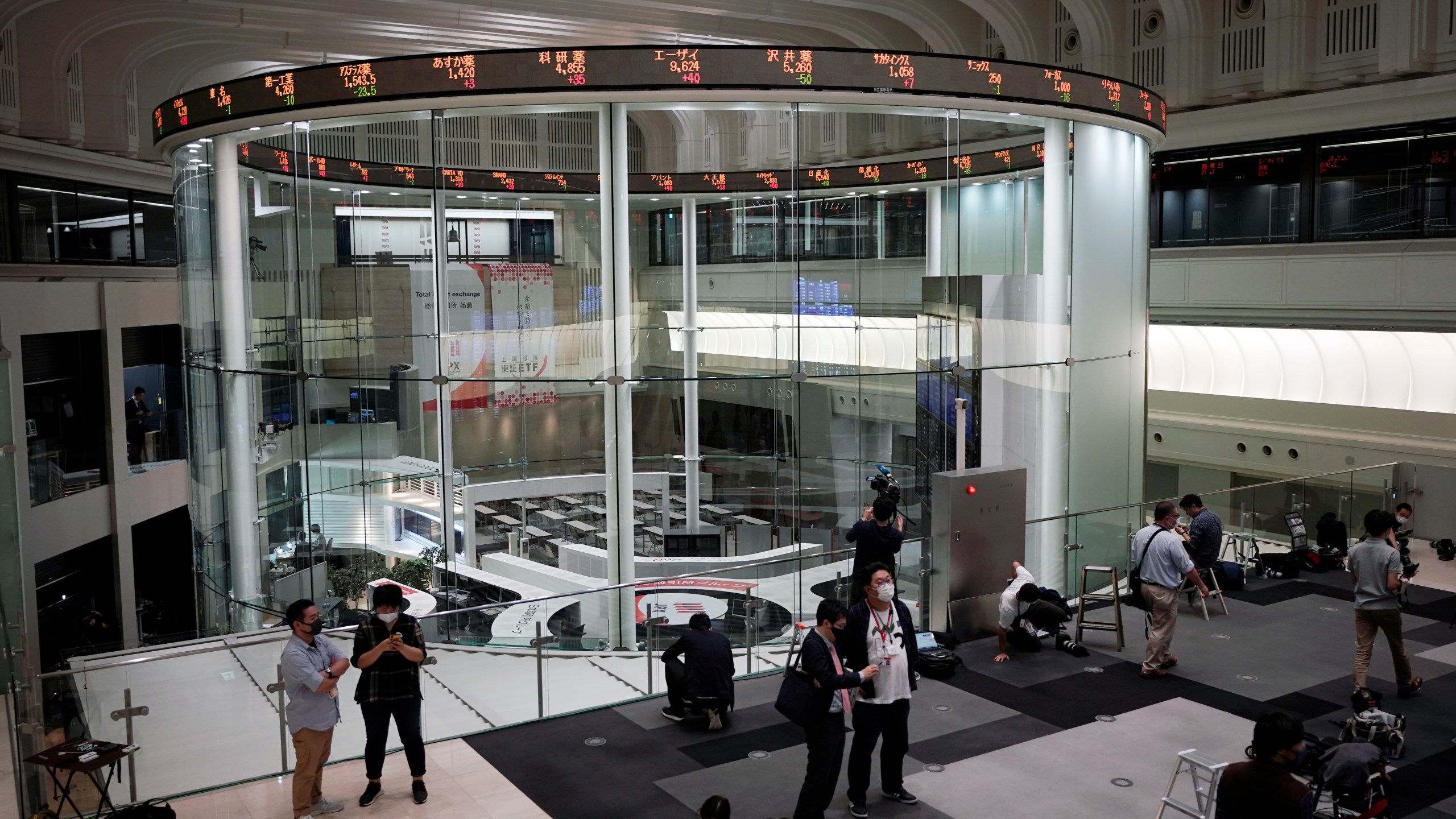 Journalists film an electronic stock board showing reopened Japan's Nikkei 225 index at Tokyo Stock Exchange on Oct. 2, 2020. (AP Photo/Eugene Hoshiko)