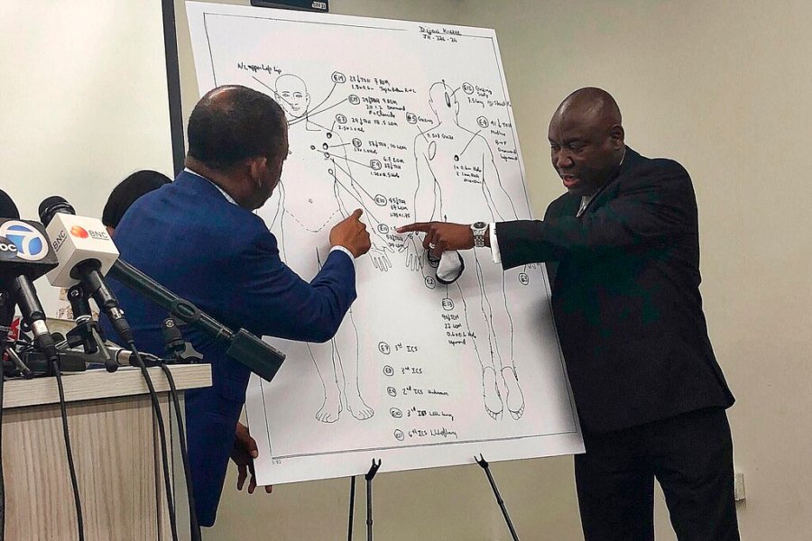 Attorneys Carl Douglas, left, and Benjamin Crump, right, point to bullet wounds on a diagram of Dijon Kizzee's body as part of an independent autopsy during a news conference in Los Angeles on Sept. 22, 2020. (AP Photo/Stefanie Dazio, File)