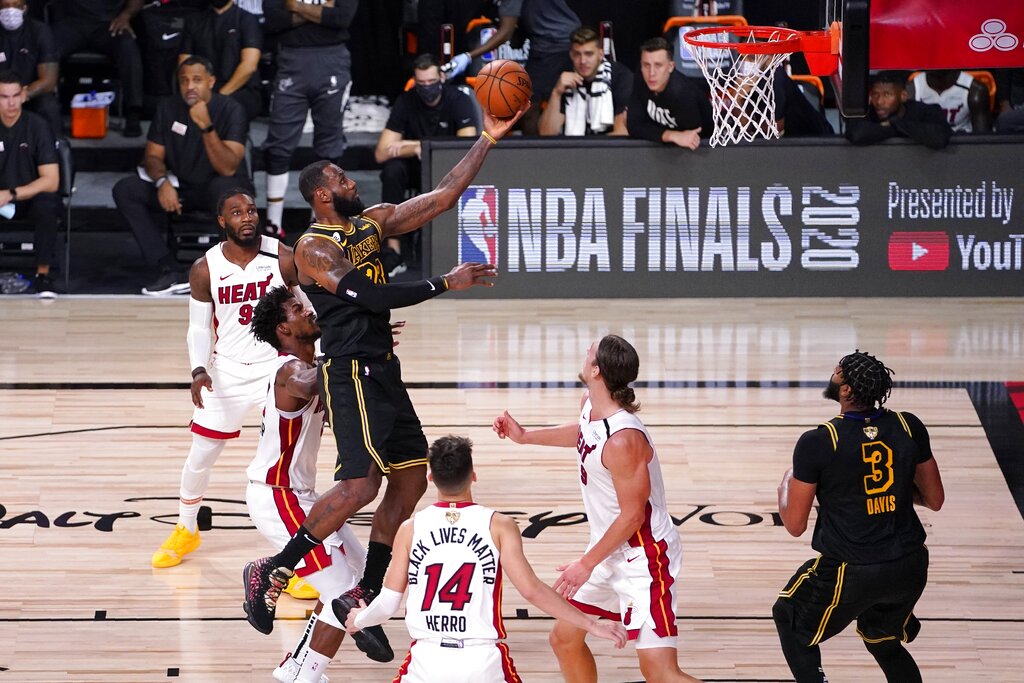 Los Angeles Lakers forward LeBron James goes up for a shot between Miami Heat's Jimmy Butler, center left, Tyler Herro and Kelly Olynyk during the second half of Game 2 of basketball's NBA Finals, Friday, Oct. 2, 2020, in Lake Buena Vista, Fla. (AP Photo/Mark J. Terrill)