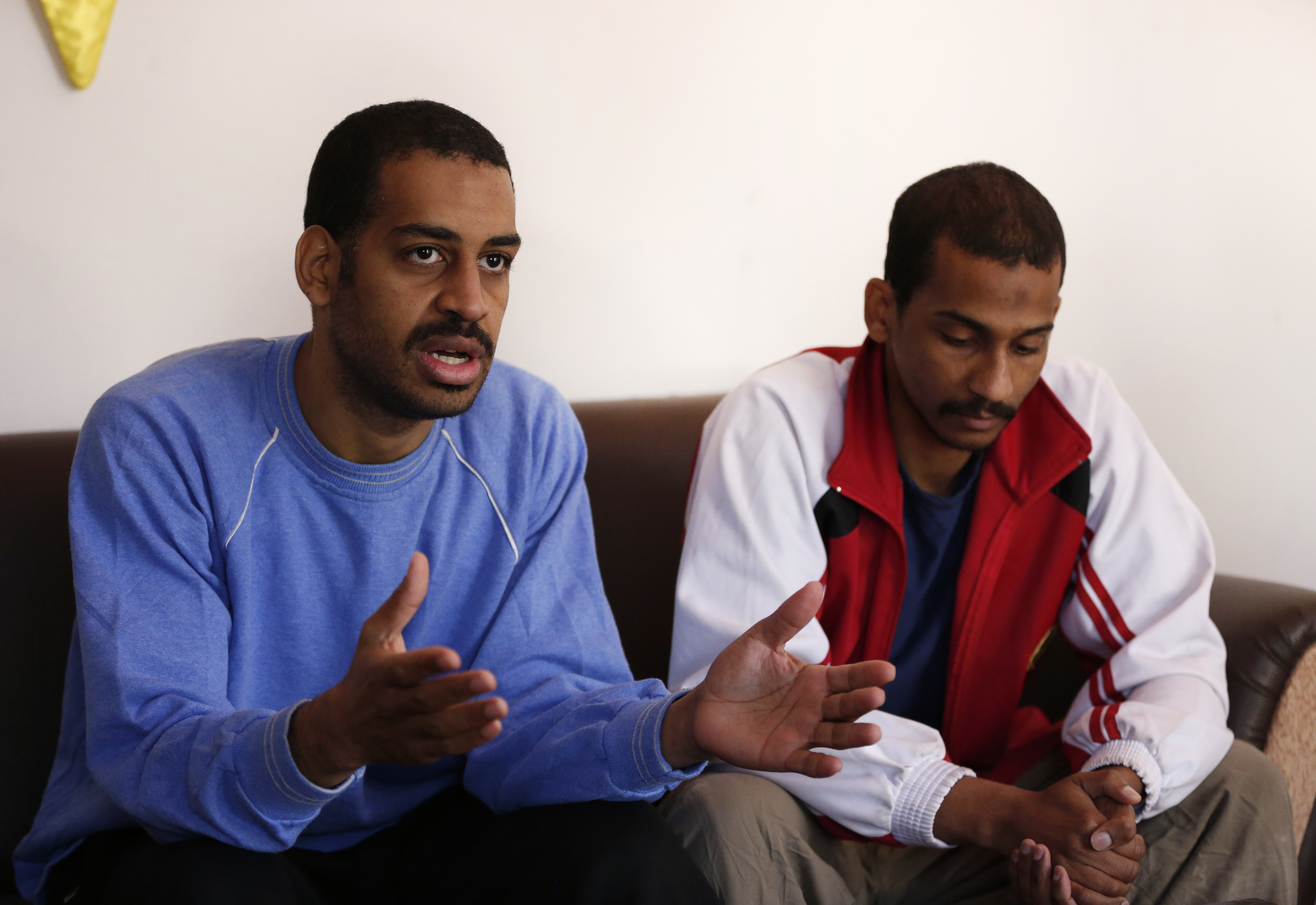 In this March 30, 2019, file photo, Alexanda Amon Kotey, left, and El Shafee Elsheikh, who were allegedly among four British jihadis who made up a brutal Islamic State cell dubbed "The Beatles," speak during an interview with The Associated Press at a security center in Kobani, Syria. The Justice Department is preparing to announce charges Wednesday against two men from Britain who joined the Islamic State and were part of a cell that beheaded Western hostages, a law enforcement official said. Their arrival in the U.S. to face charges sets the stage for arguably the most sensational terrorism prosecution since the 2014 case against the suspected ringleader of a deadly attack on the diplomatic compound in Benghazi, Libya.(AP Photo/Hussein Malla, File)