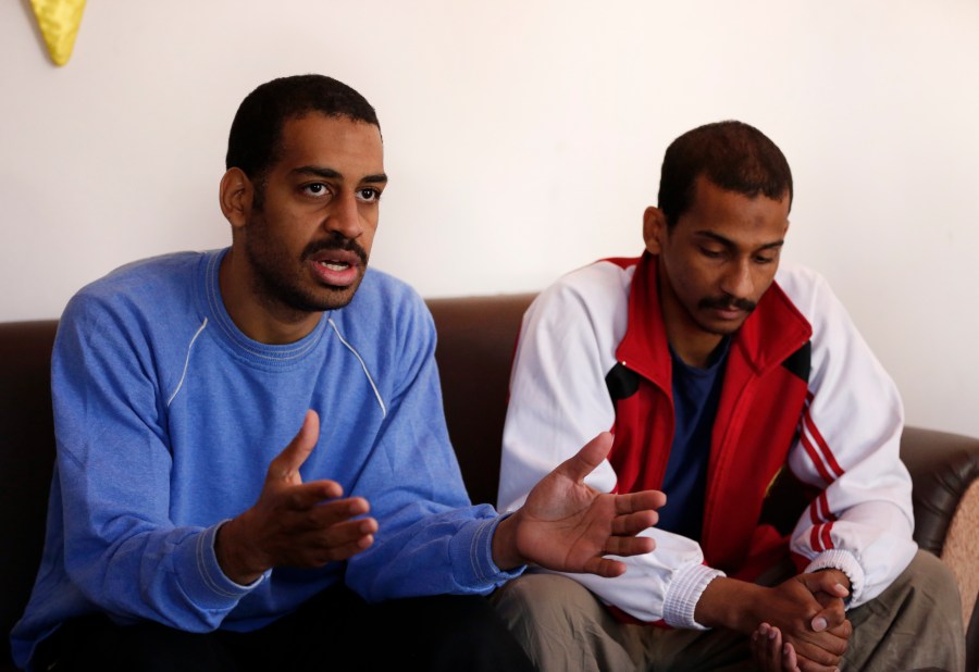 In this March 30, 2019, file photo, Alexanda Amon Kotey, left, and El Shafee Elsheikh, who were allegedly among four British jihadis who made up a brutal Islamic State cell dubbed "The Beatles," speak during an interview with The Associated Press at a security center in Kobani, Syria. The Justice Department is preparing to announce charges Wednesday against two men from Britain who joined the Islamic State and were part of a cell that beheaded Western hostages, a law enforcement official said. Their arrival in the U.S. to face charges sets the stage for arguably the most sensational terrorism prosecution since the 2014 case against the suspected ringleader of a deadly attack on the diplomatic compound in Benghazi, Libya.(AP Photo/Hussein Malla, File)